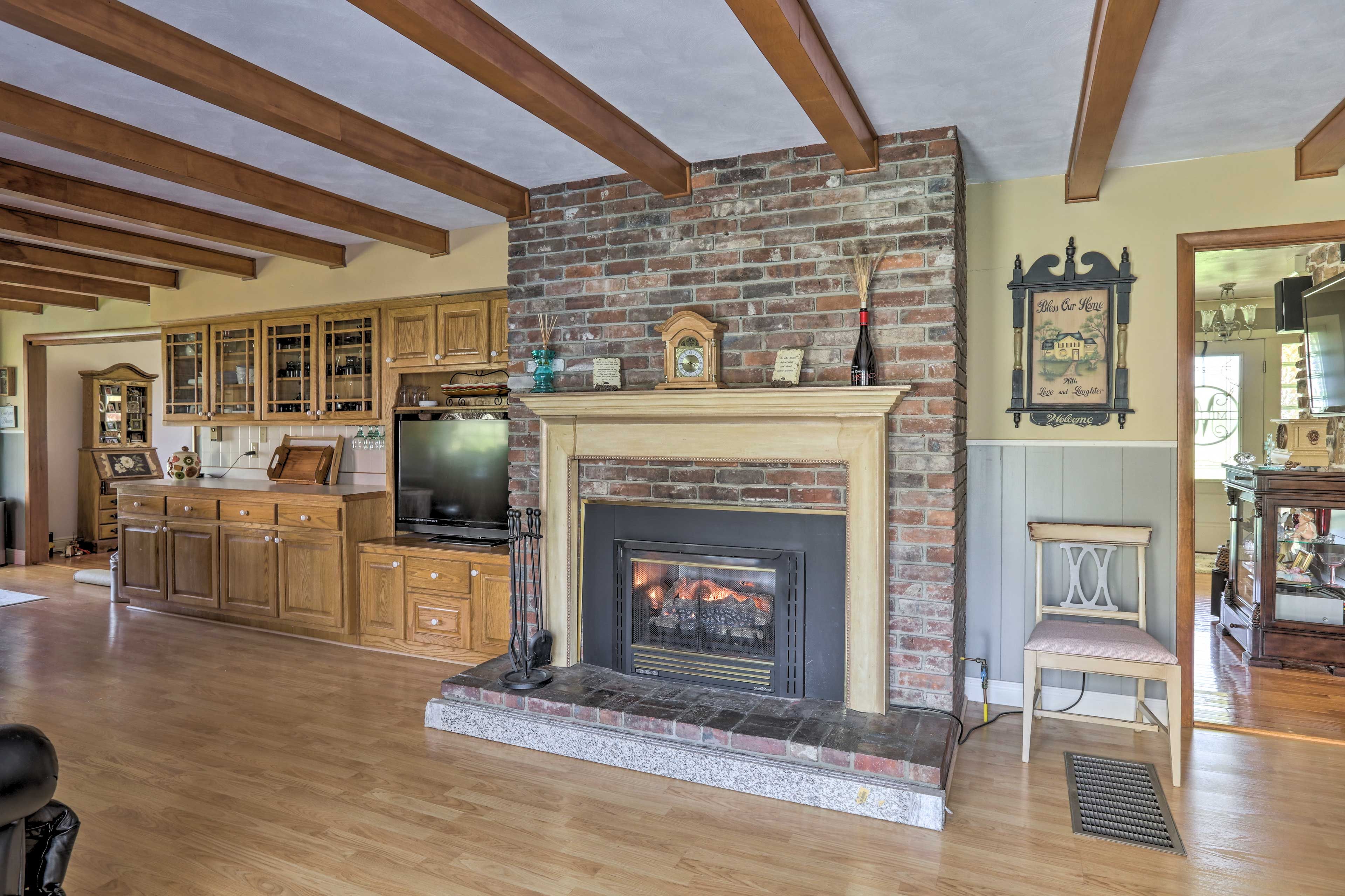The den features a brick, gas-burning fireplace.
