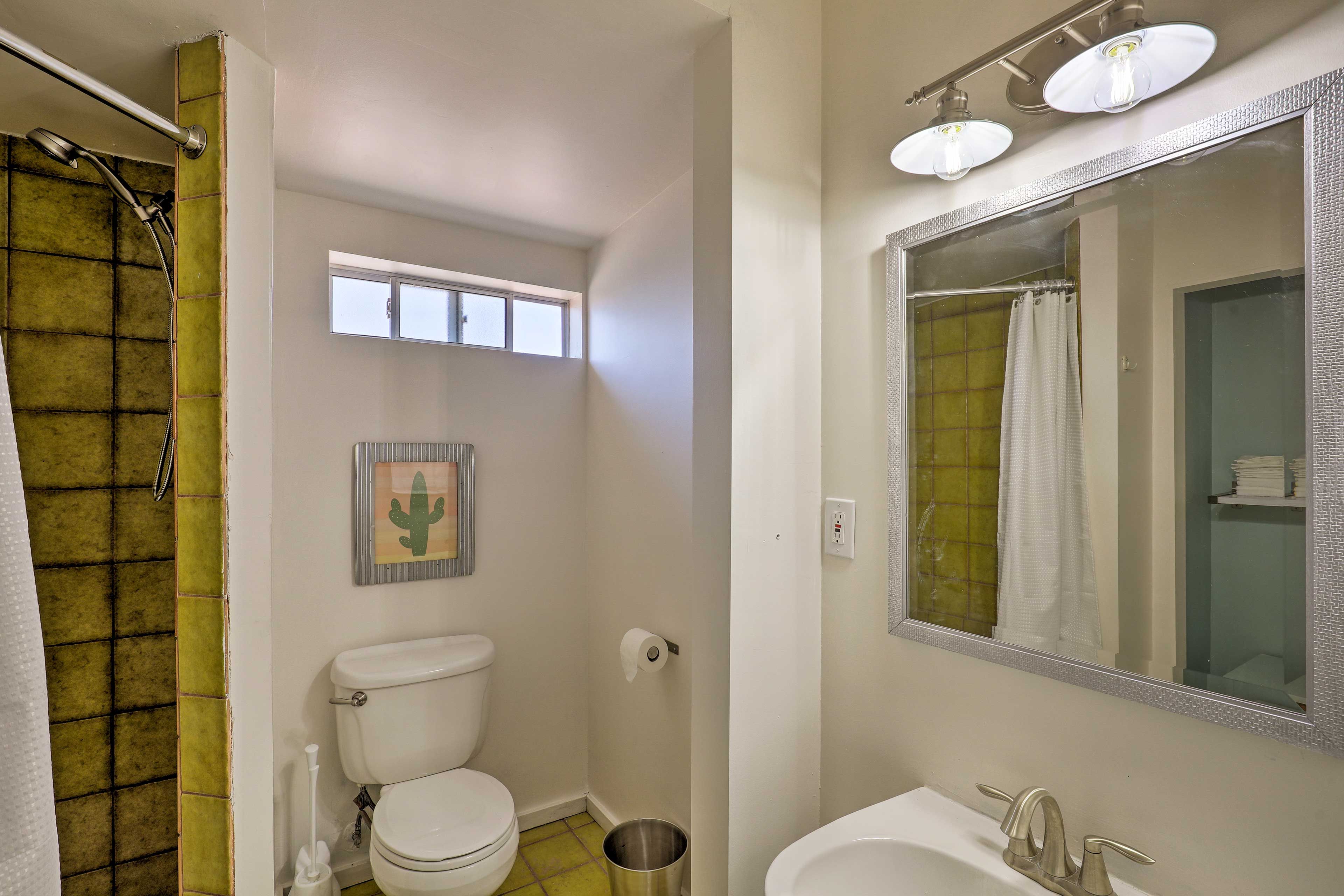 The full bathroom features a spacious, tiled shower.