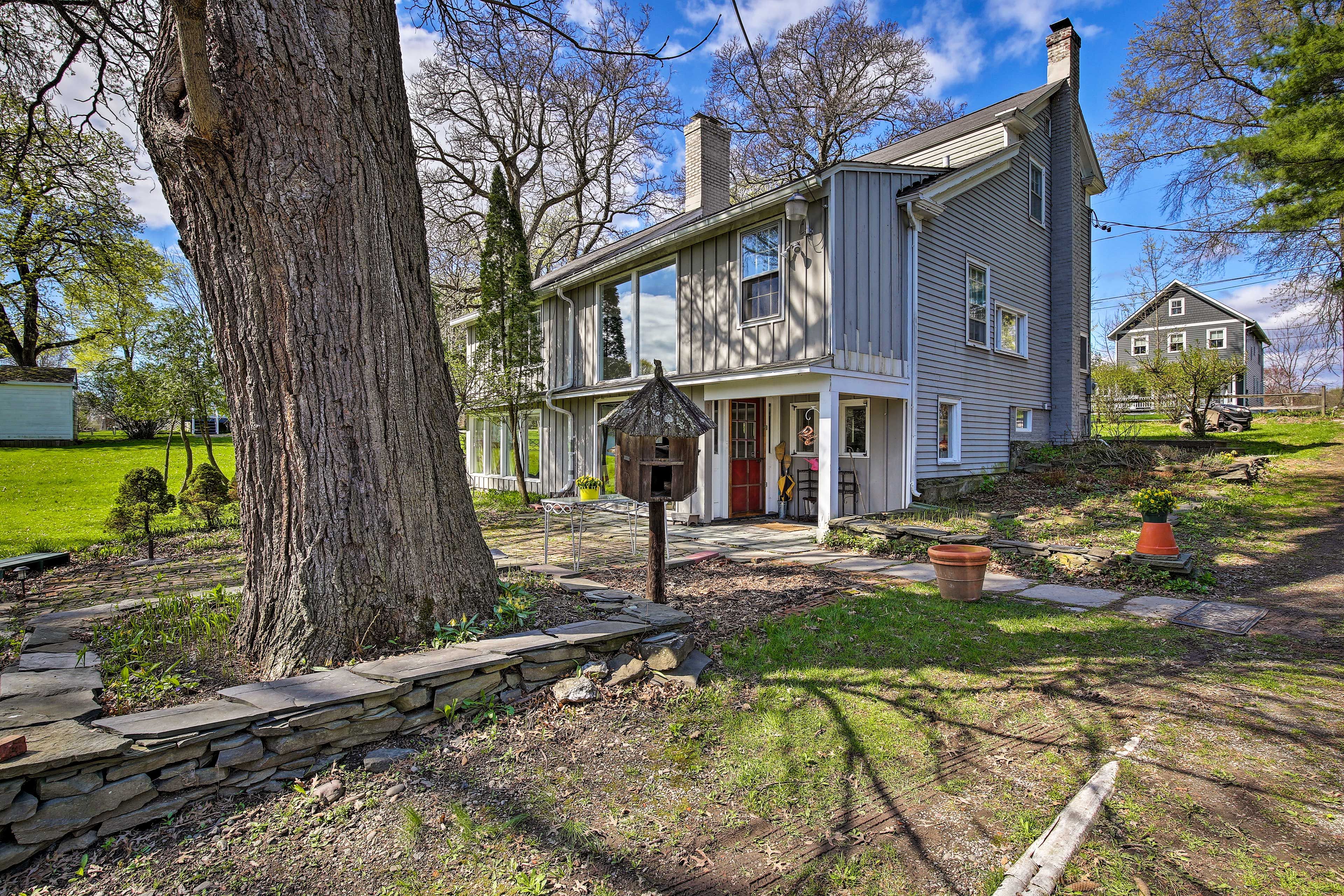 Charming landscaping surrounds the quaint house.