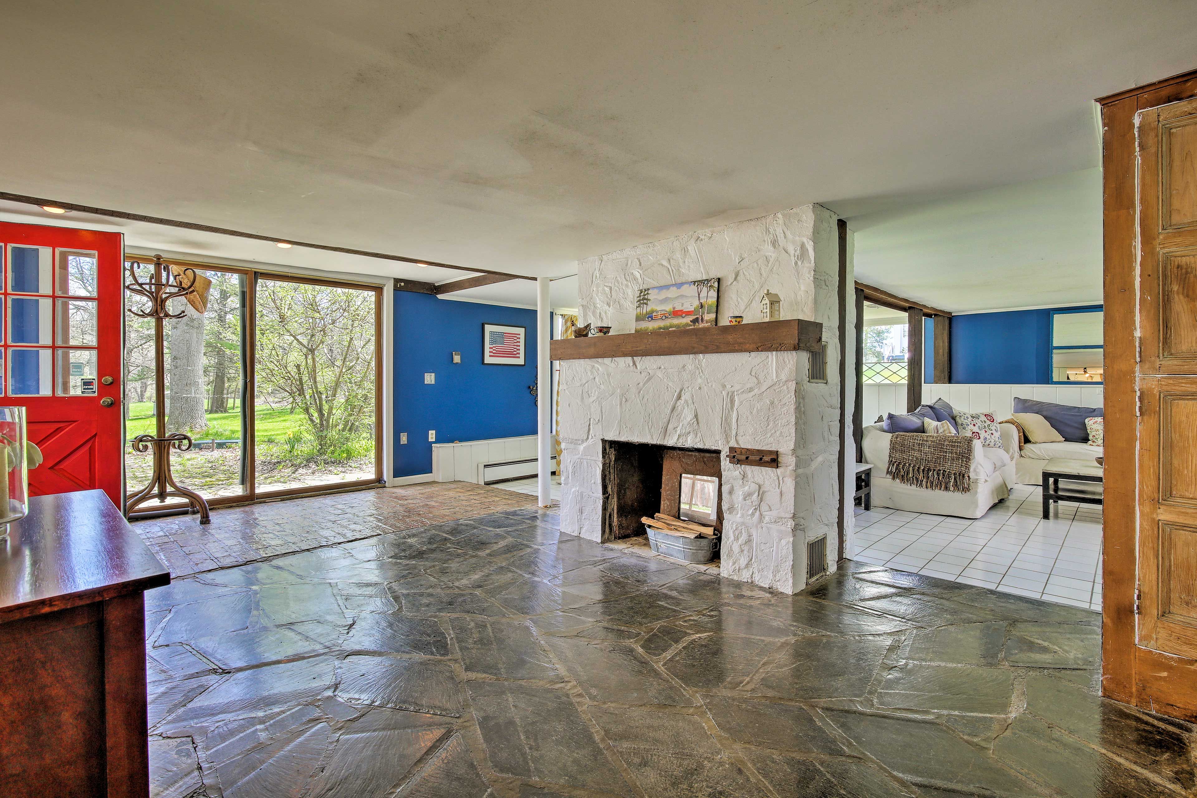 Floor-to-ceiling windows open to the woodland surroundings.