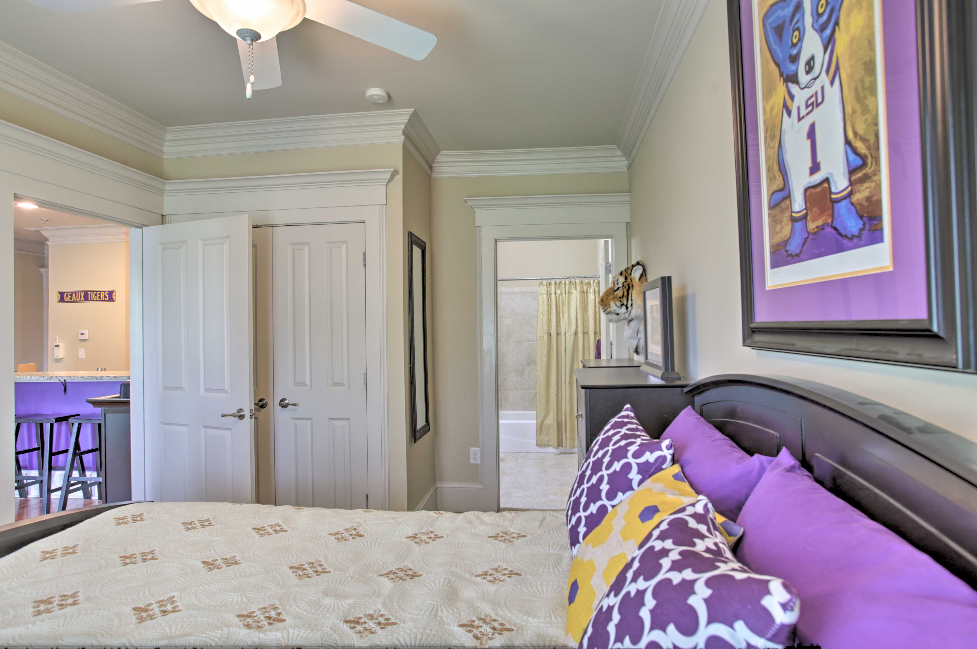 The bedroom has ample storage space and a ceiling fan.
