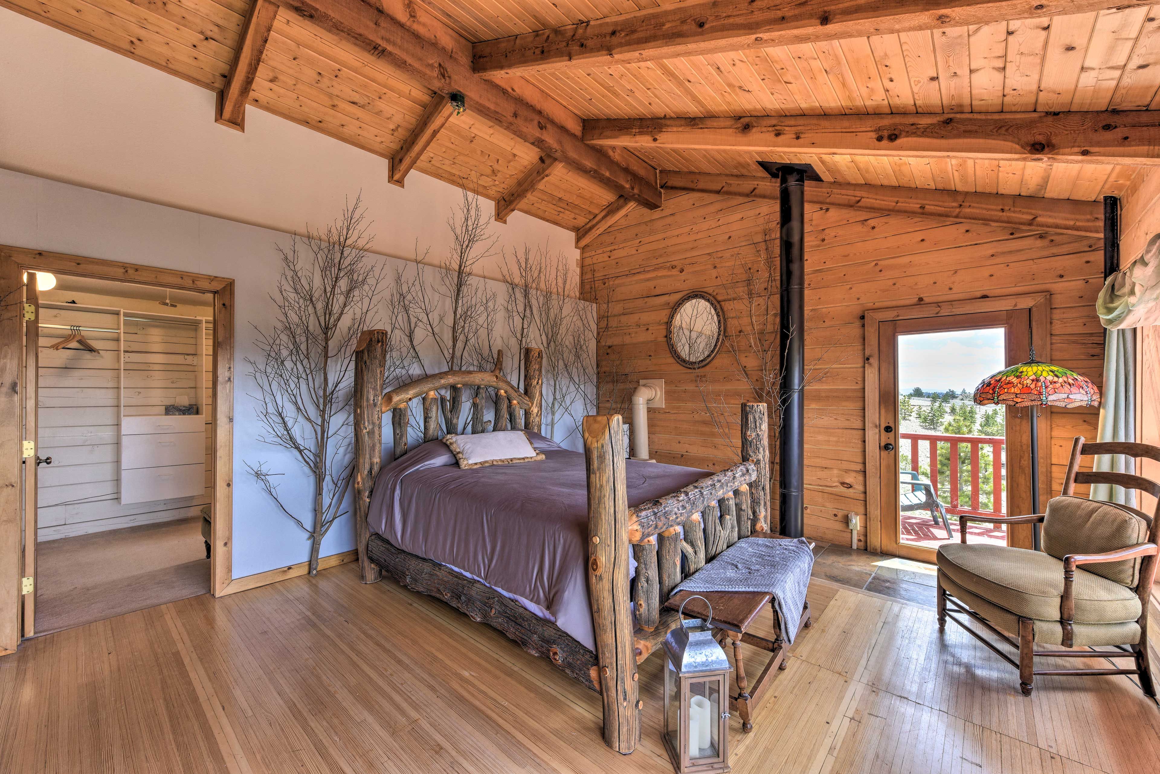 This spacious master bedroom features high ceilings and rustic decor.