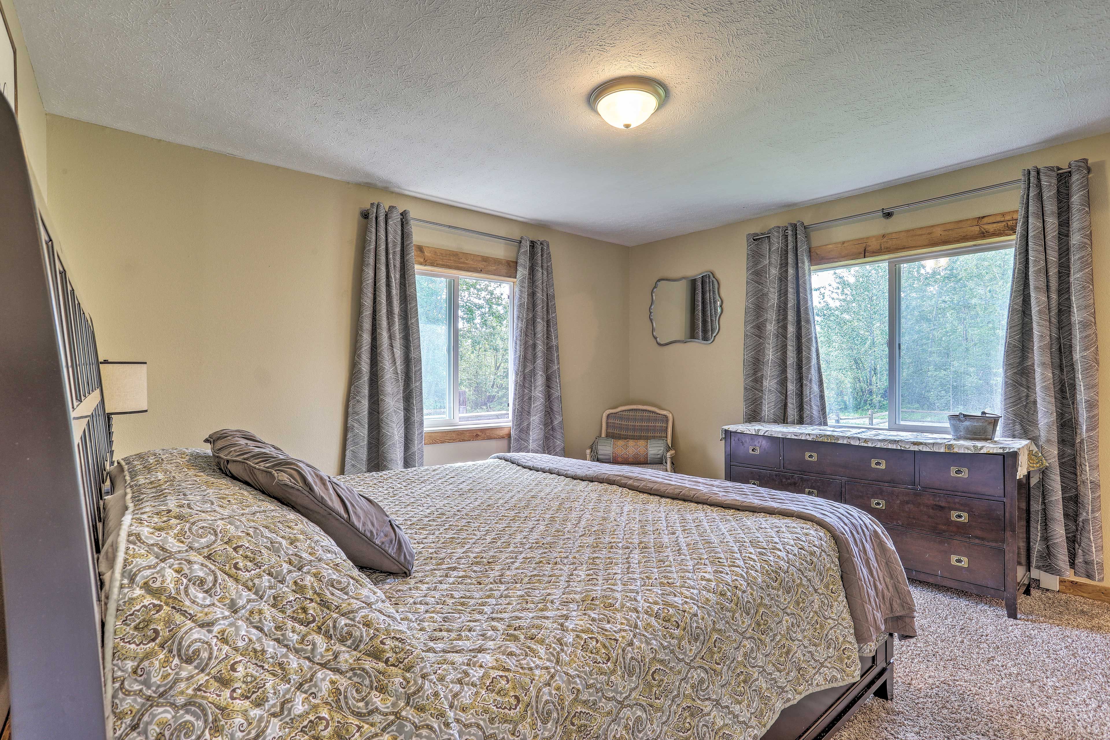 The corner bedroom is outfitted with 2 windows boasting forested views.