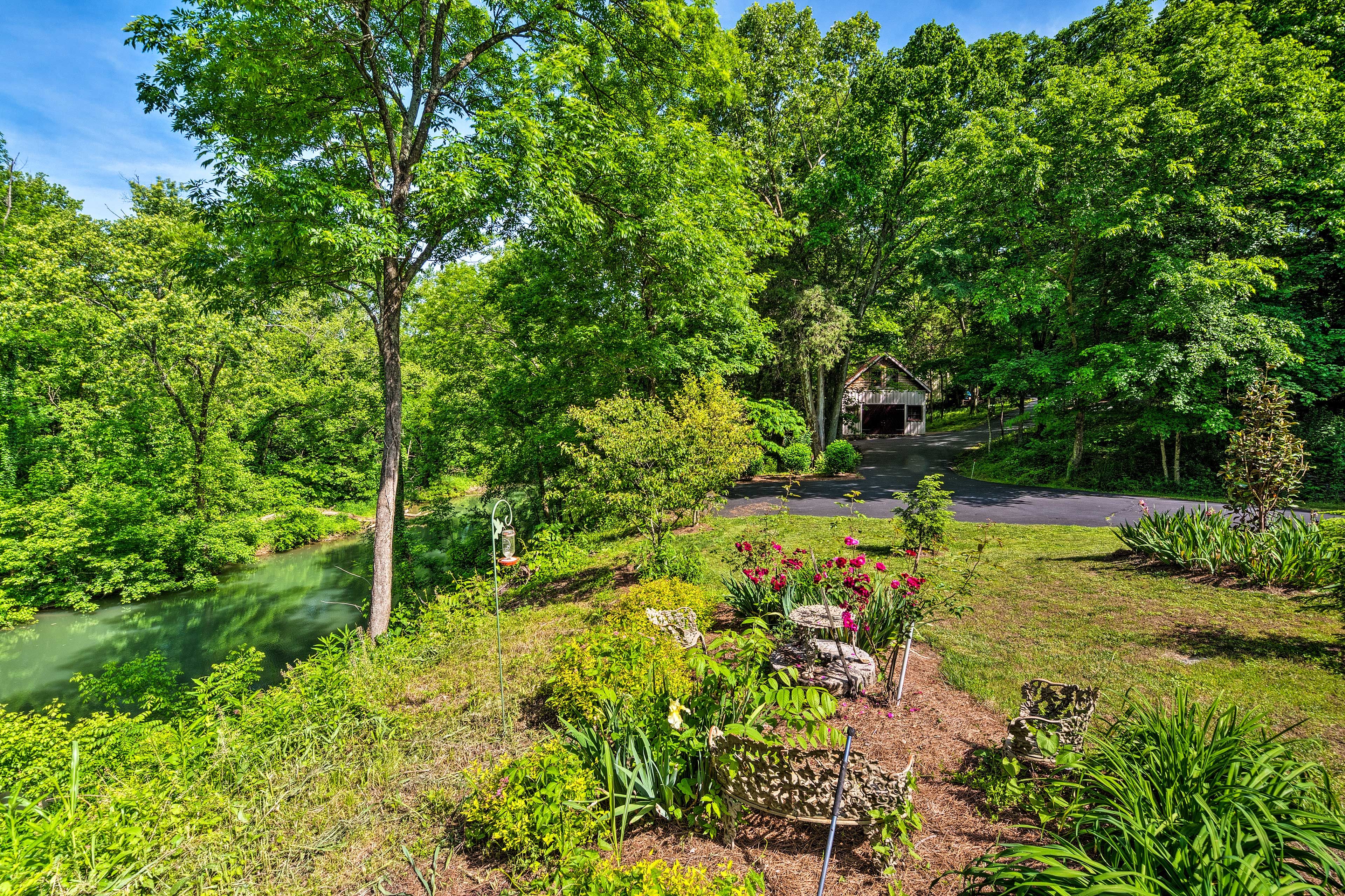 The beautiful outdoor space includes a garden, picnic table, and swinging bench.