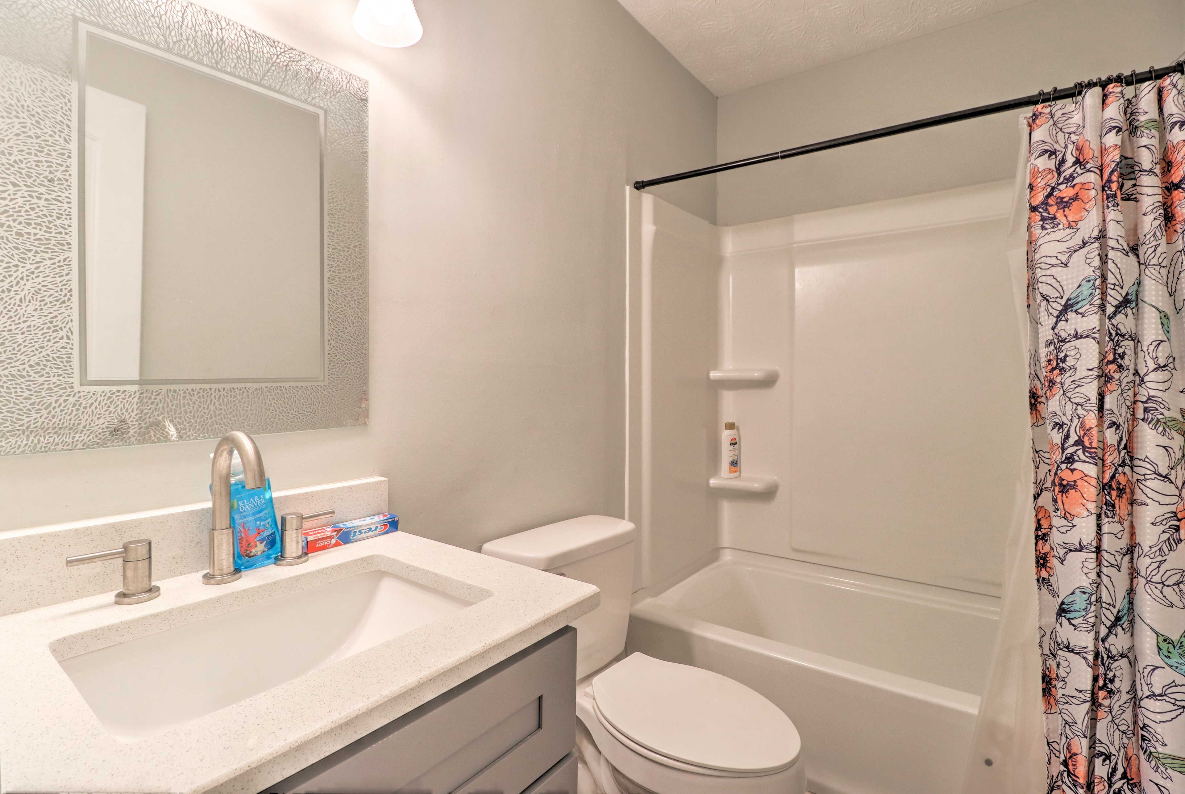 This full bathroom boasts a shower/tub combo and toiletries.