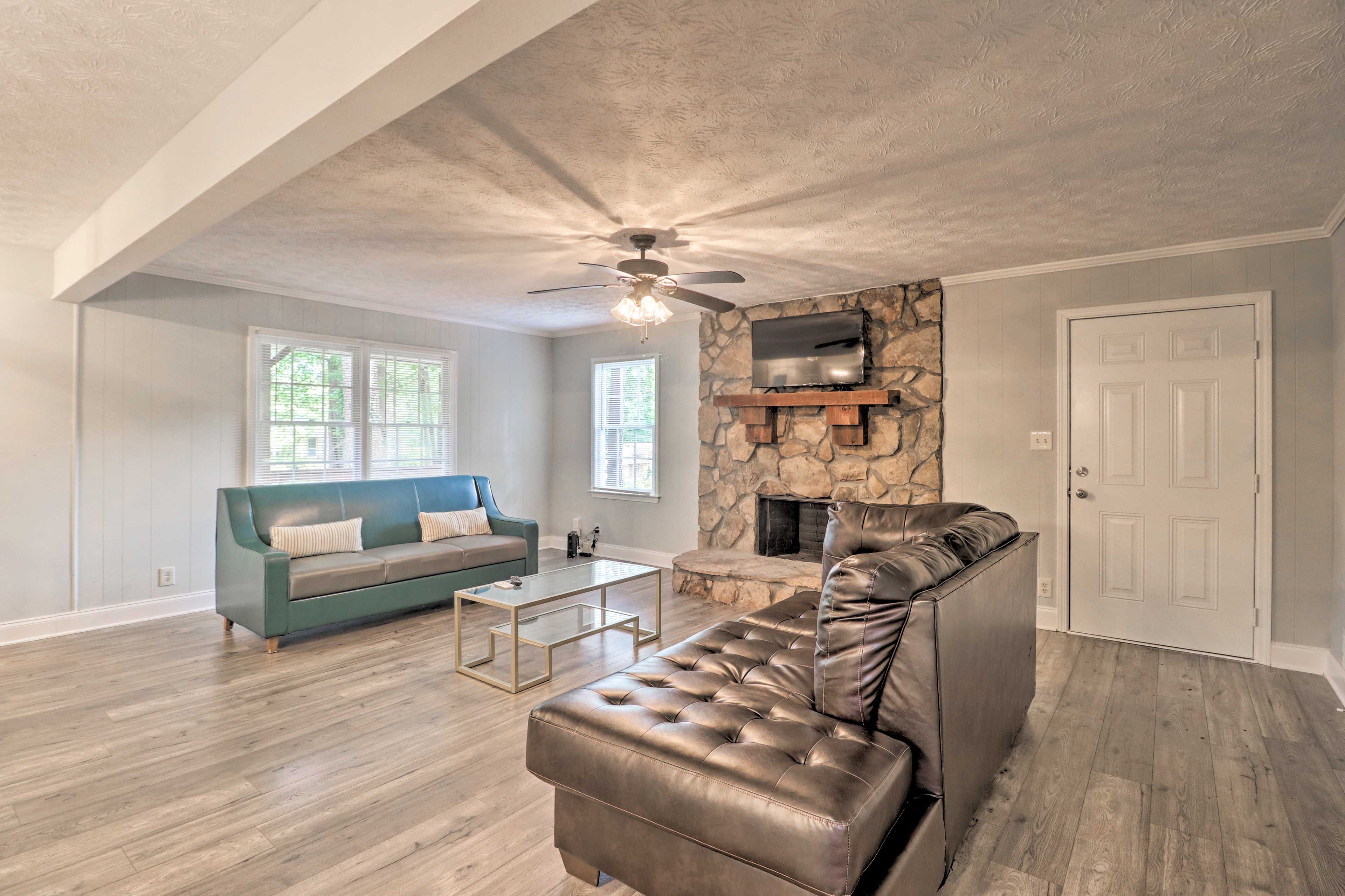 A flat-screen Smart TV is perched atop the stone fireplace.