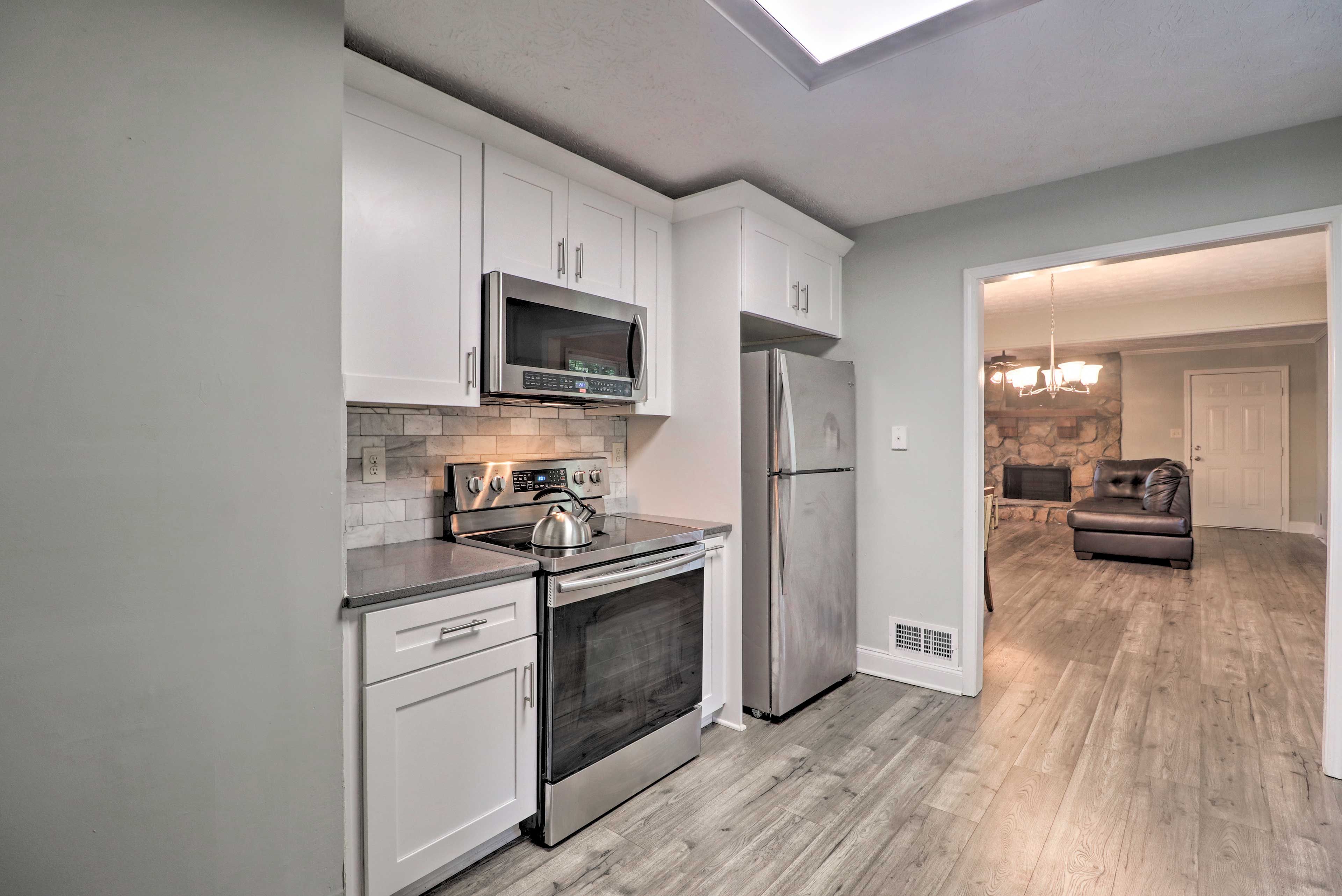 The fully equipped kitchen sits just through the broad entryway.