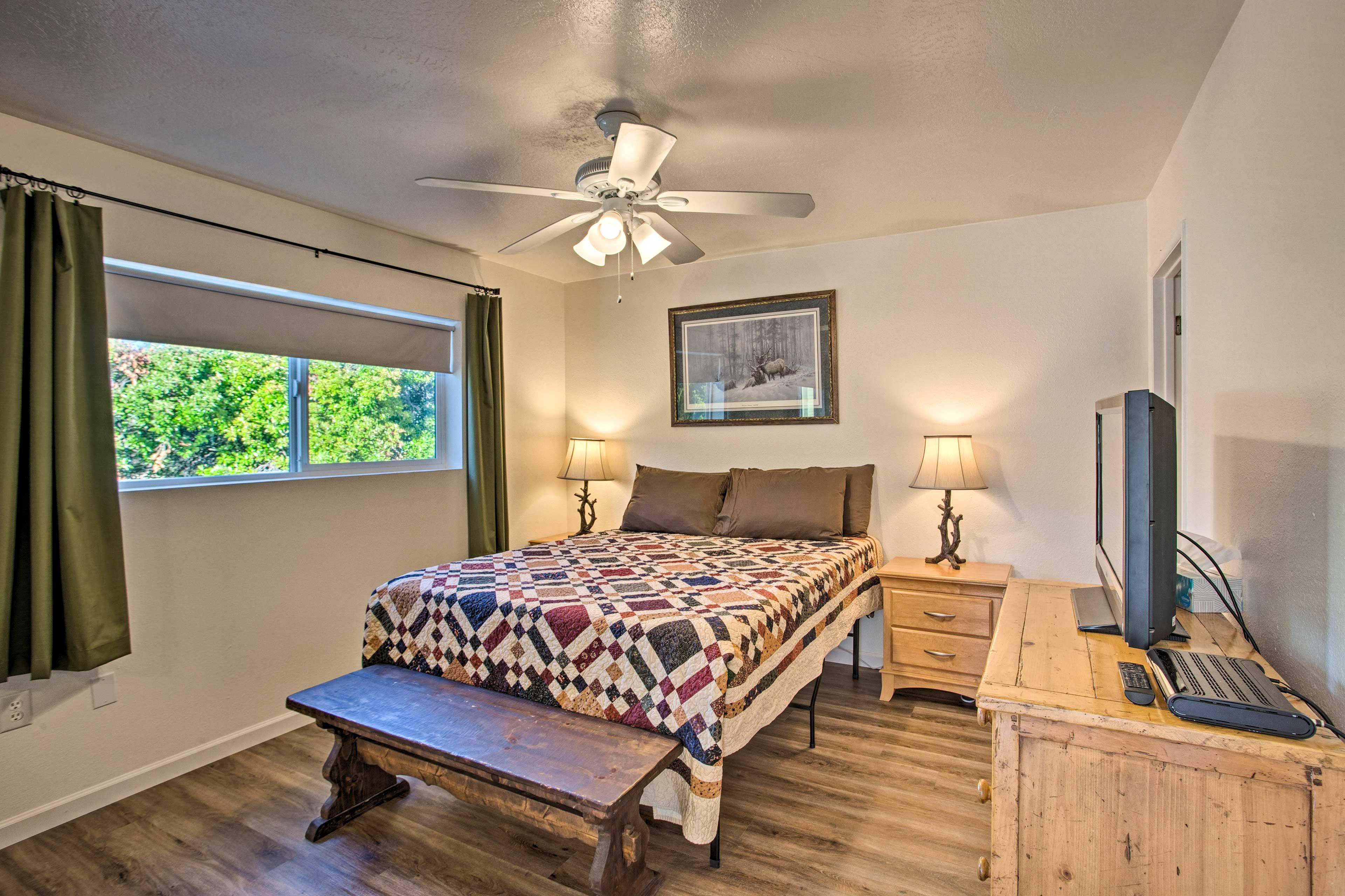 The first bedroom boasts a queen-sized bed and a large window.