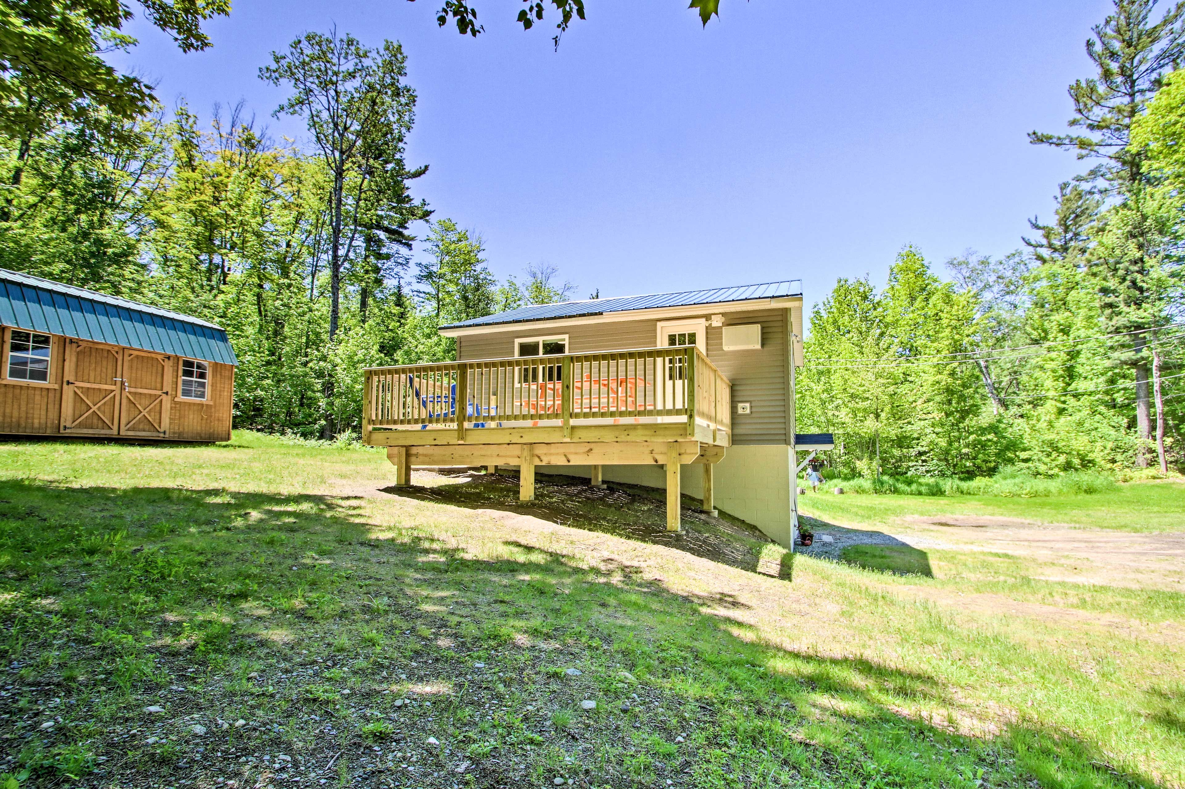 The vacation rental sits on an open clearing surrounded by trees.