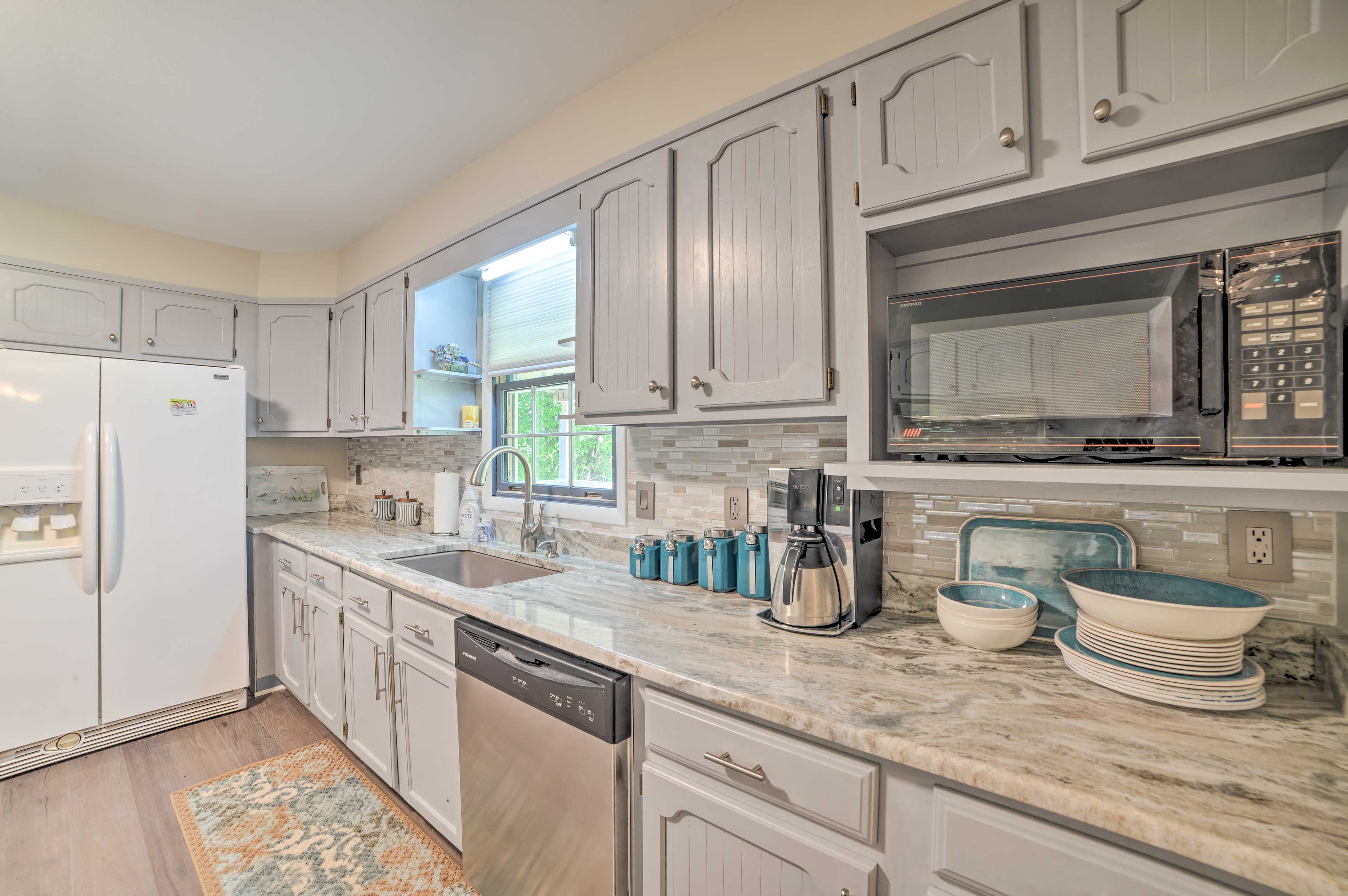 The space is complete with granite countertops, dishware, and flatware.