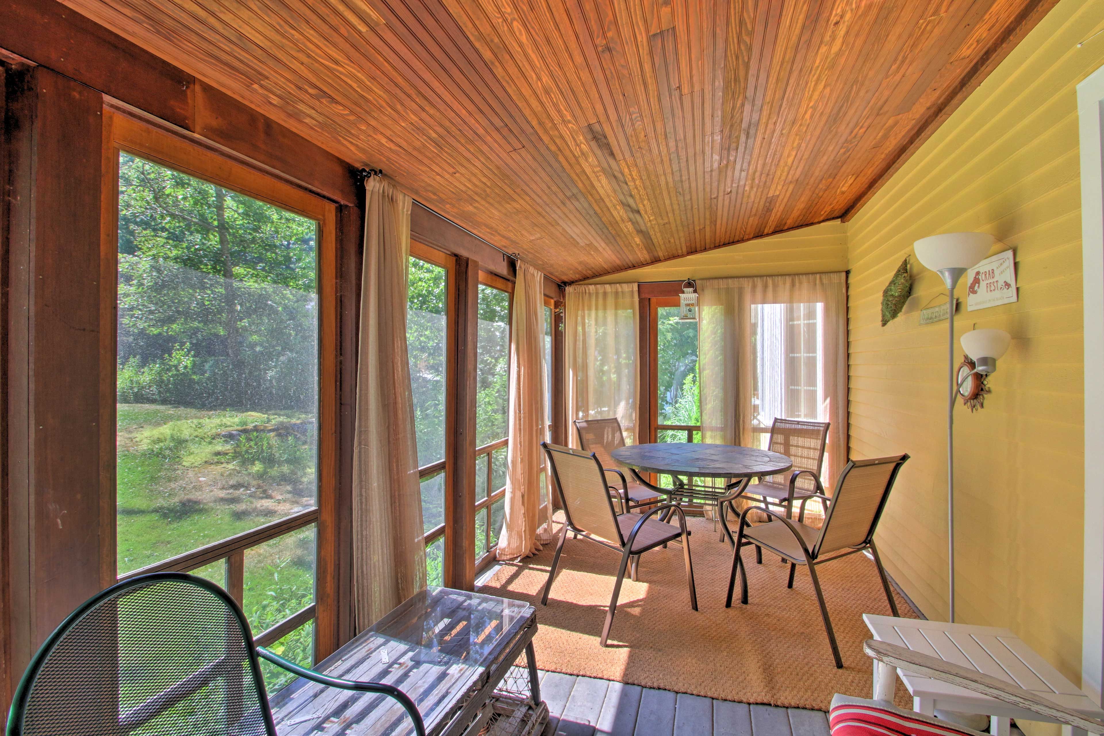 Enjoy the summer air on the screened-in porch.