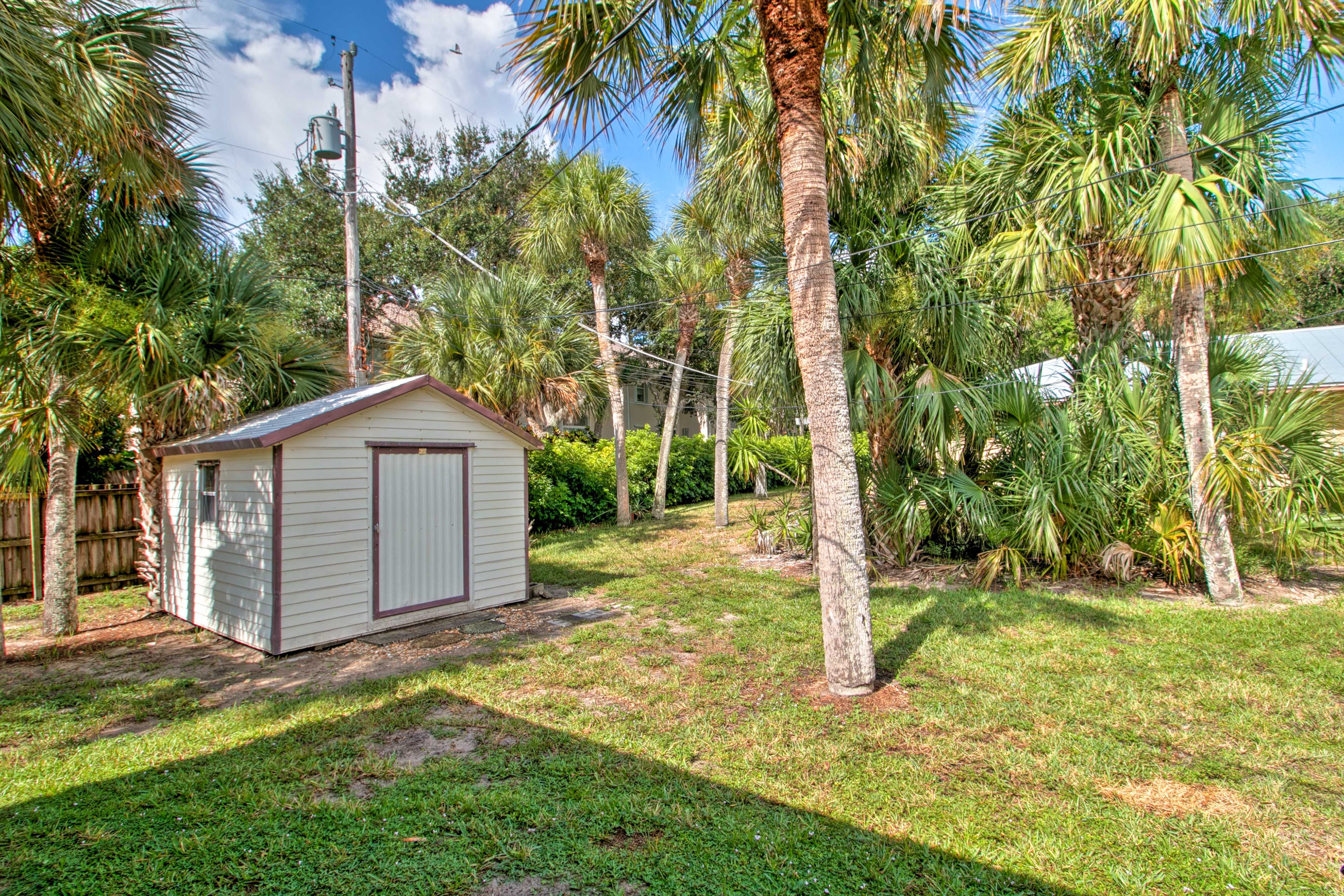 The back yard is surrounded by tropical foliage.