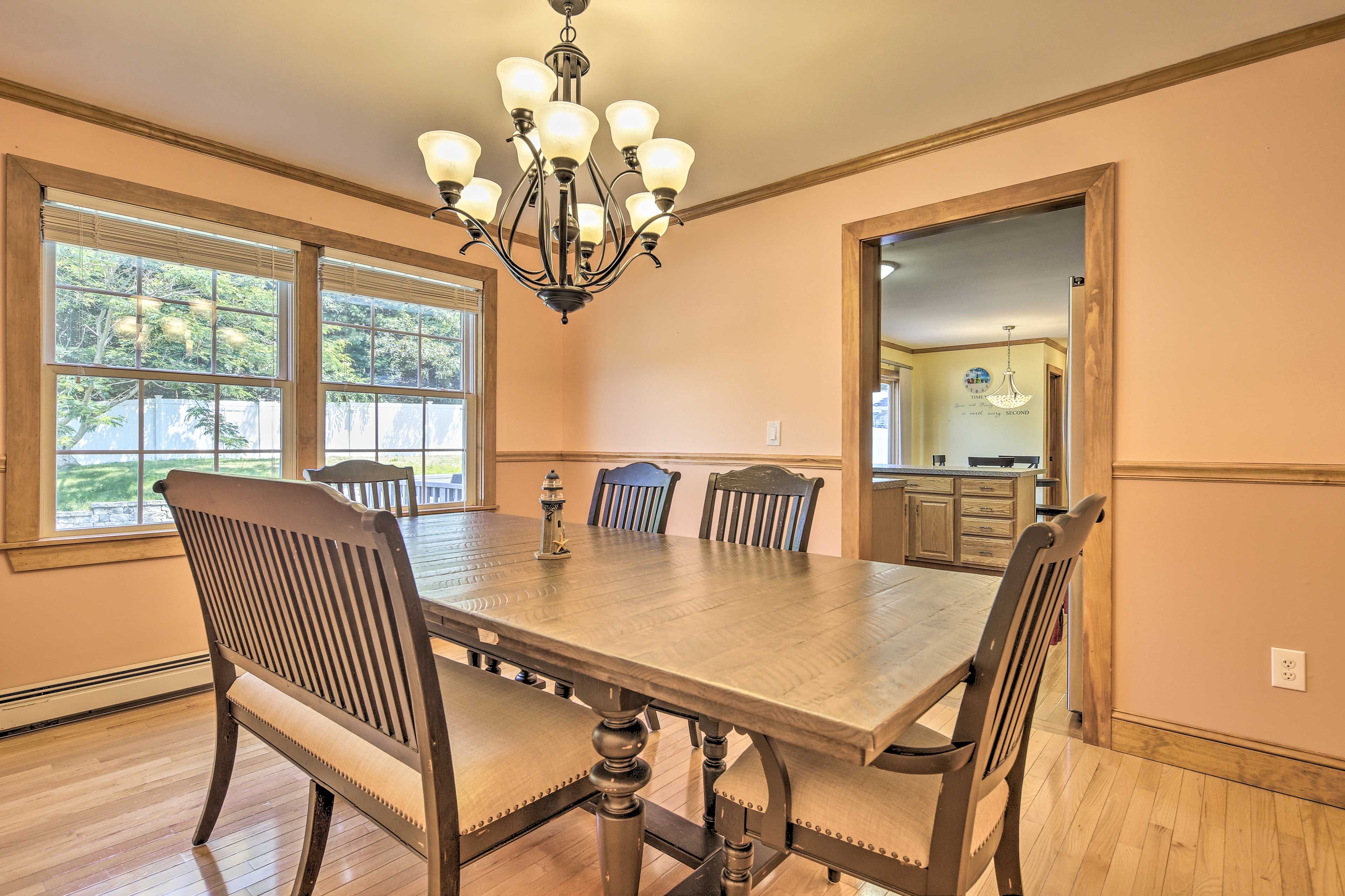 A 6-person dining table awaits on the other side of the kitchen.