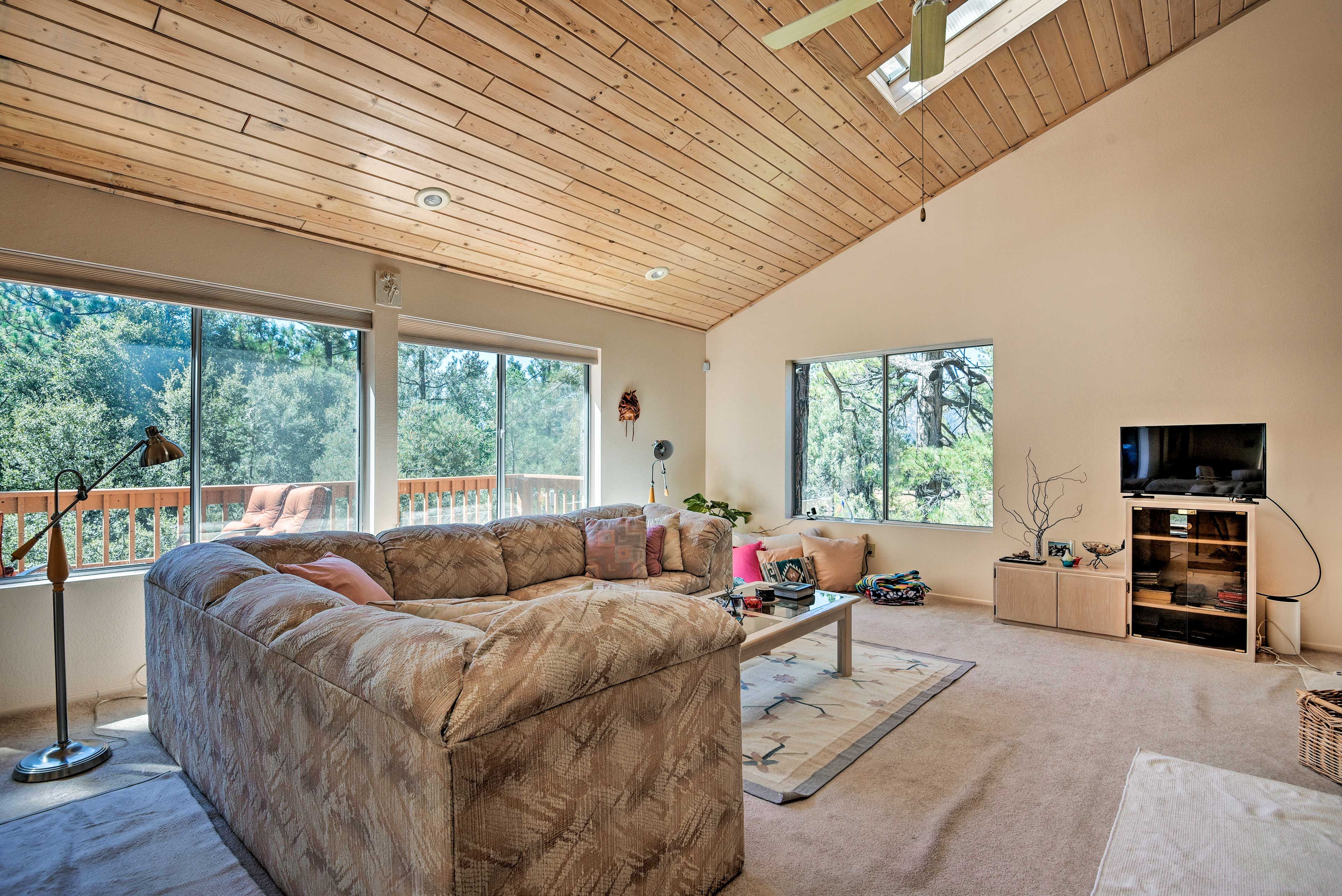 The living area is bathed in natural light through the wall-to-wall windows.