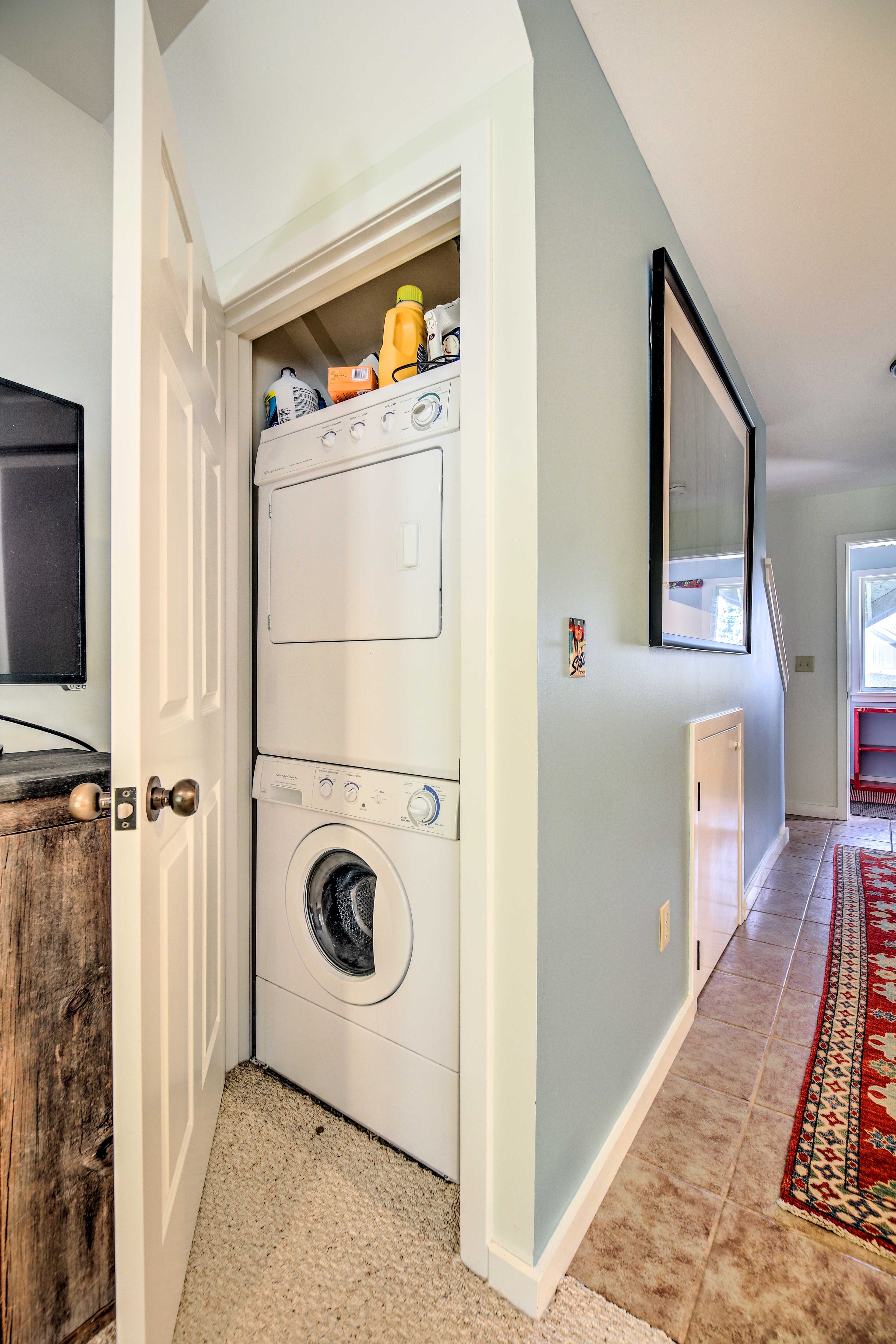 The washer and dryer are located in the living room closet.