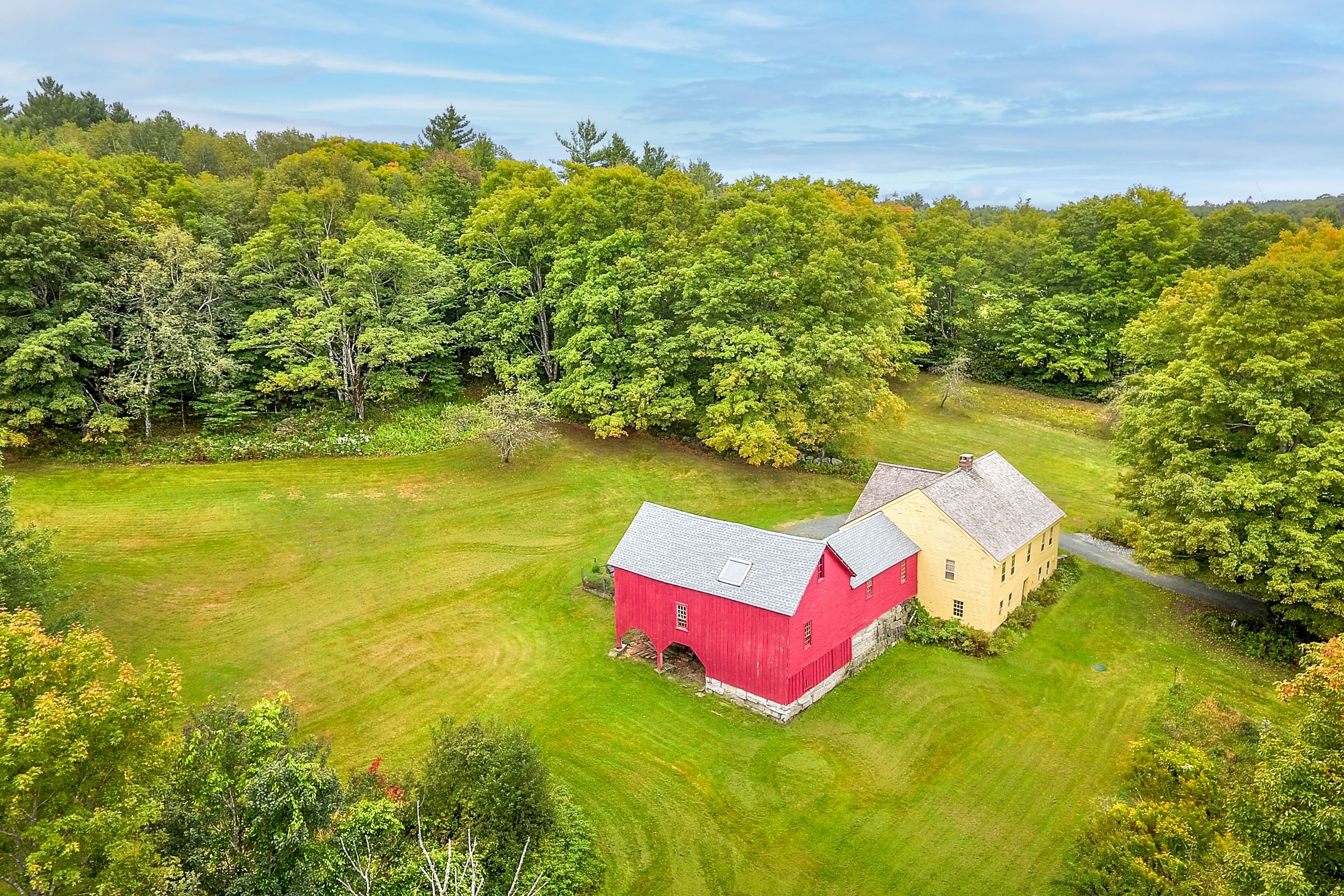 This farmhouse sits on 20 private acres nestled beside a preserve.