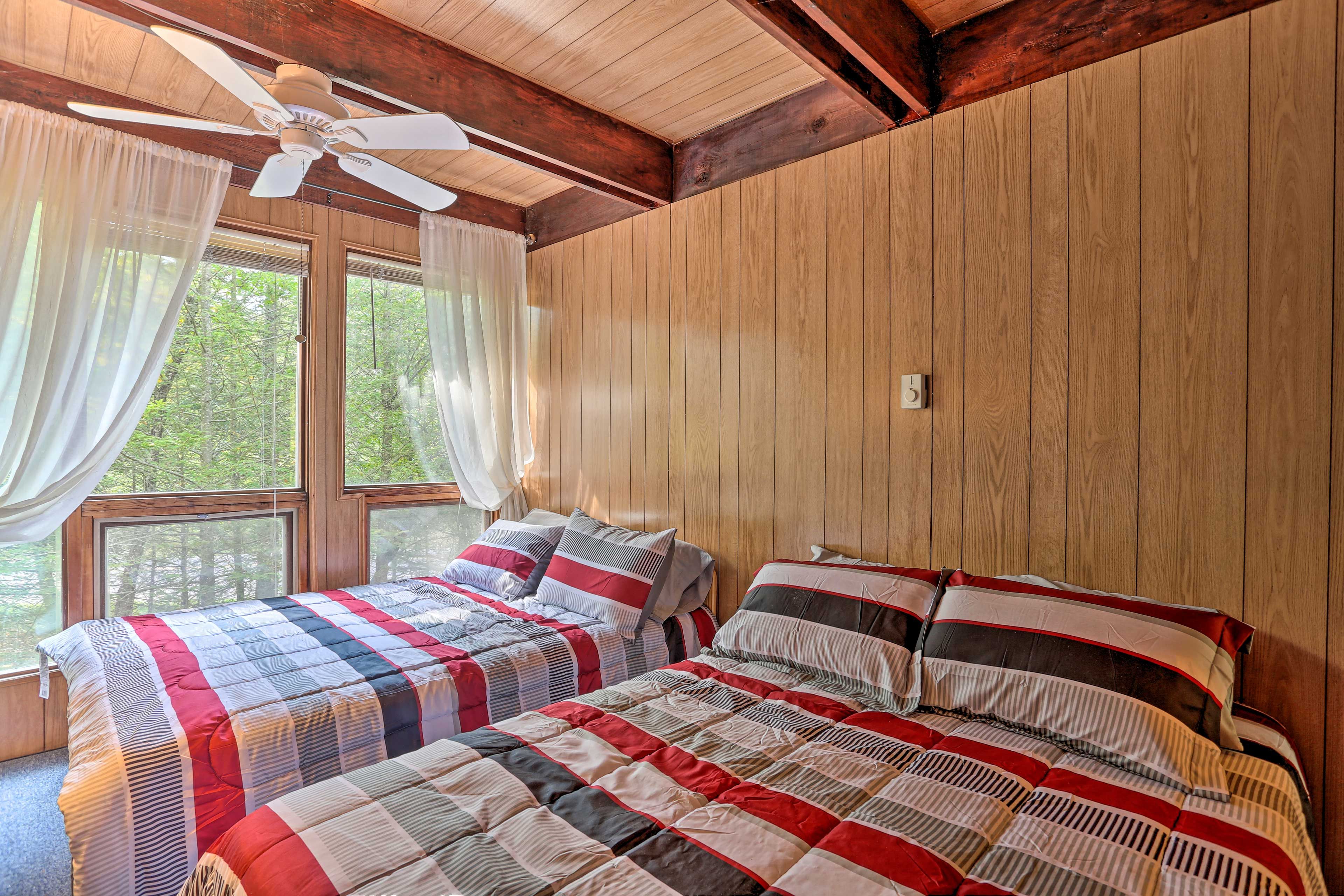 Experience serene woodland views from the privacy of this bedroom.