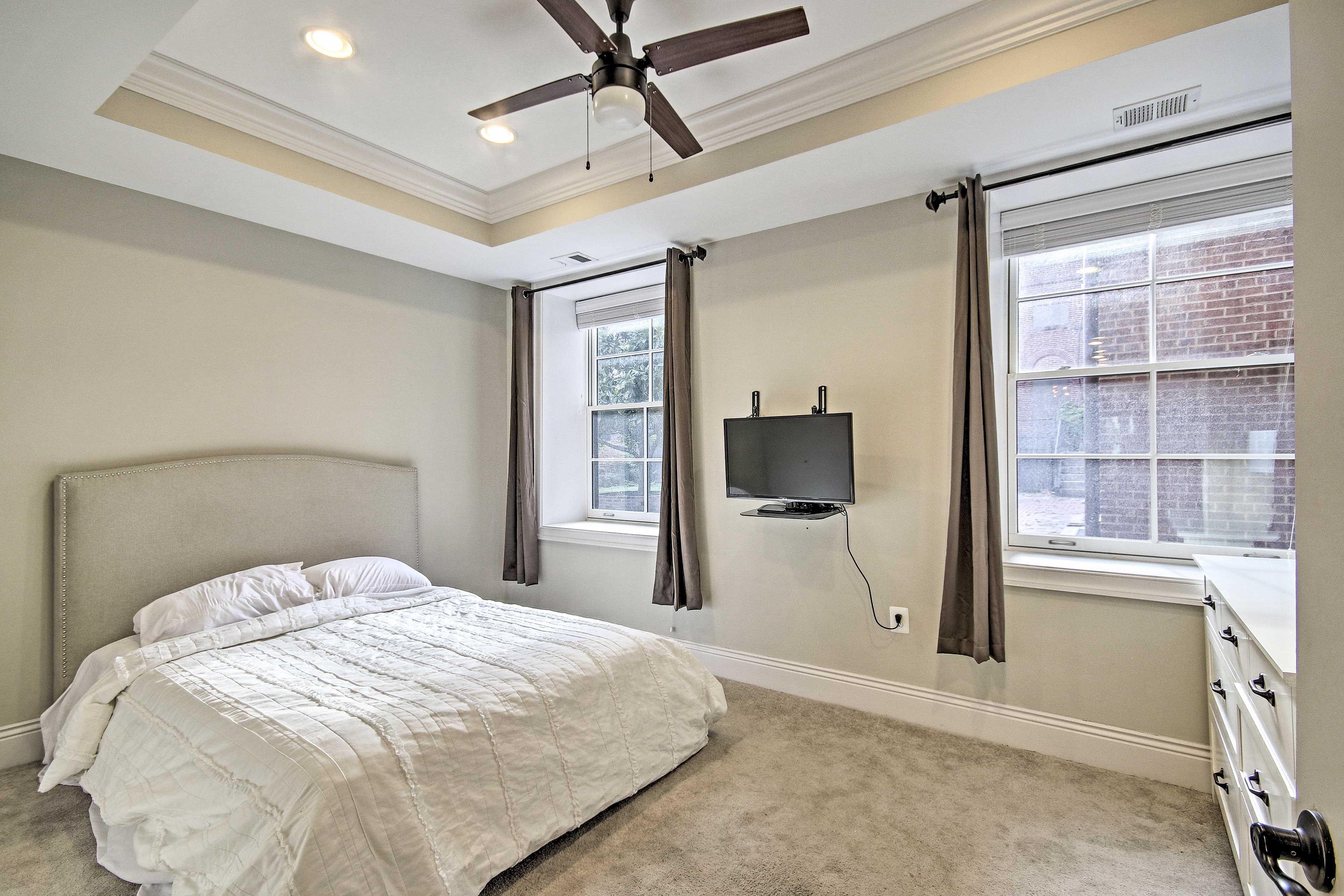 The primary bedroom stands apart with a queen bed and flat-screen TV.