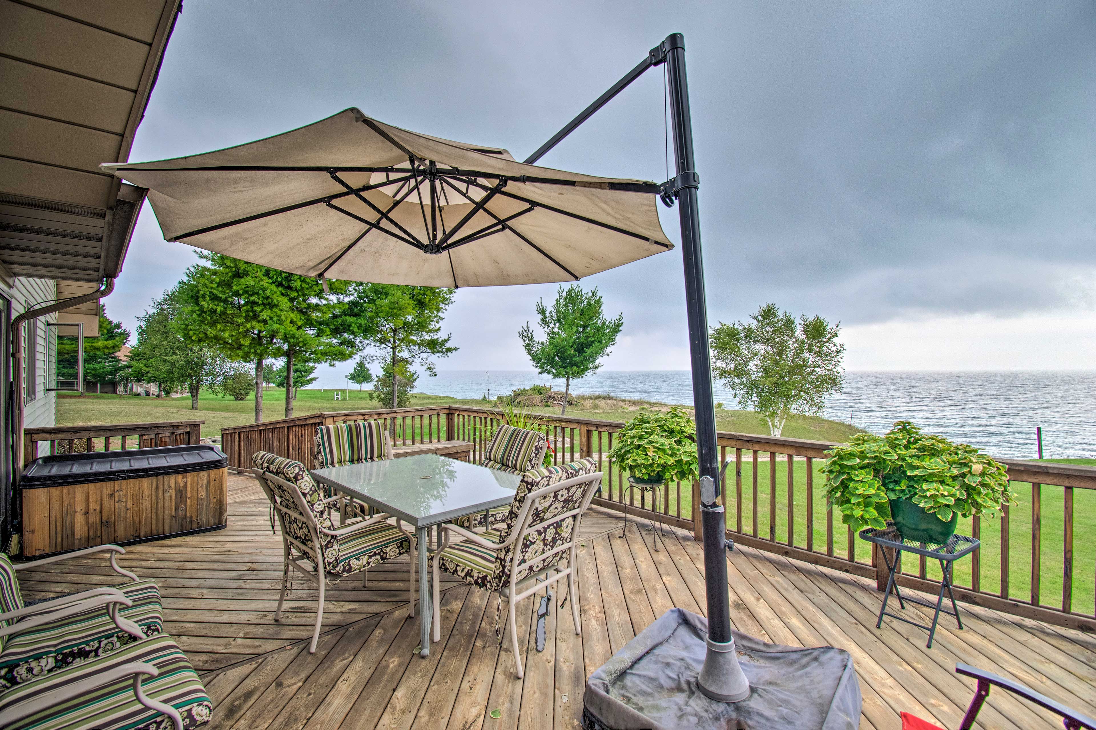 This lakefront home features a large deck complete with patio table and umbrella