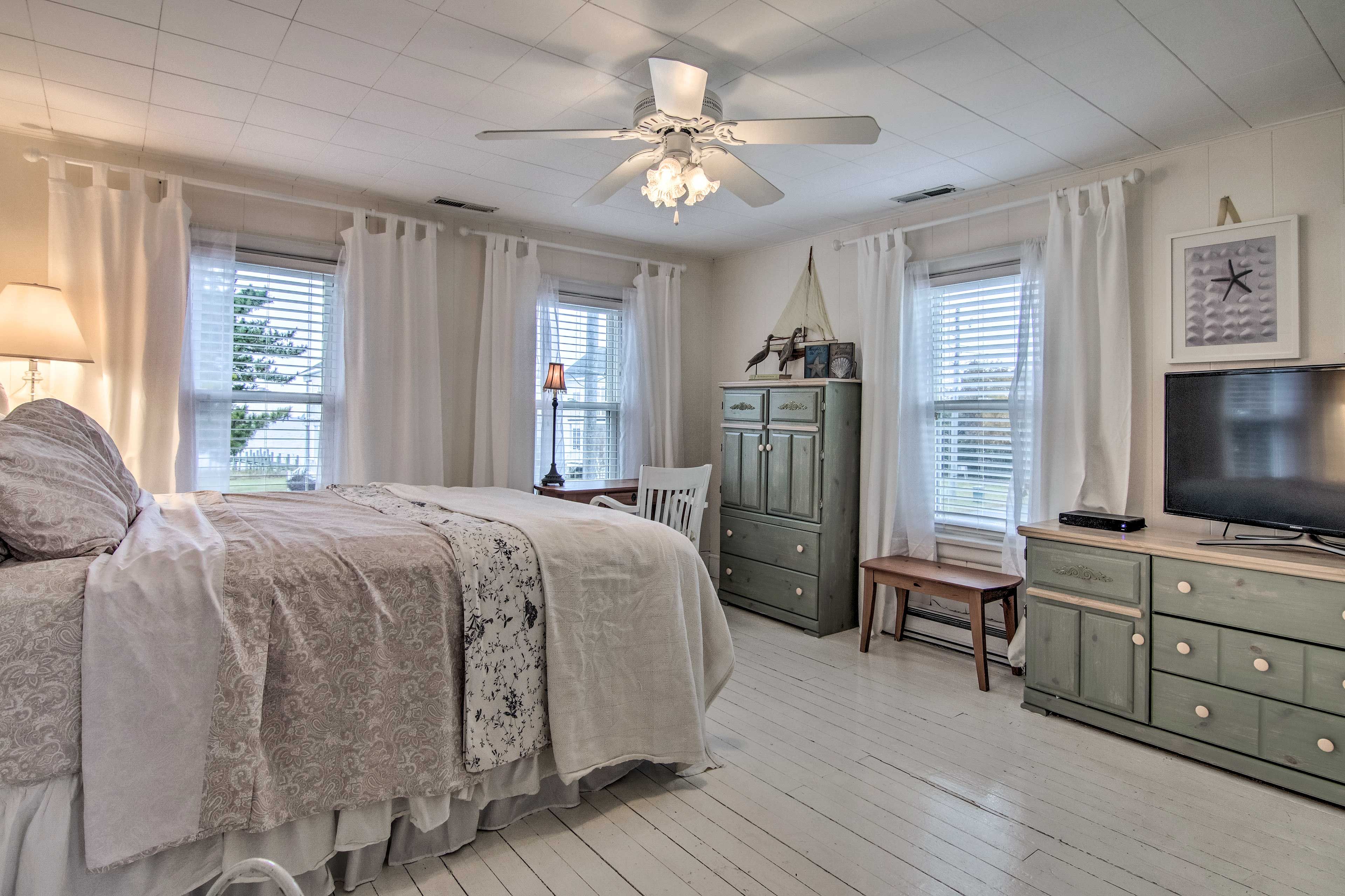 The first bedroom features beachy decor and a cozy queen-size bed.