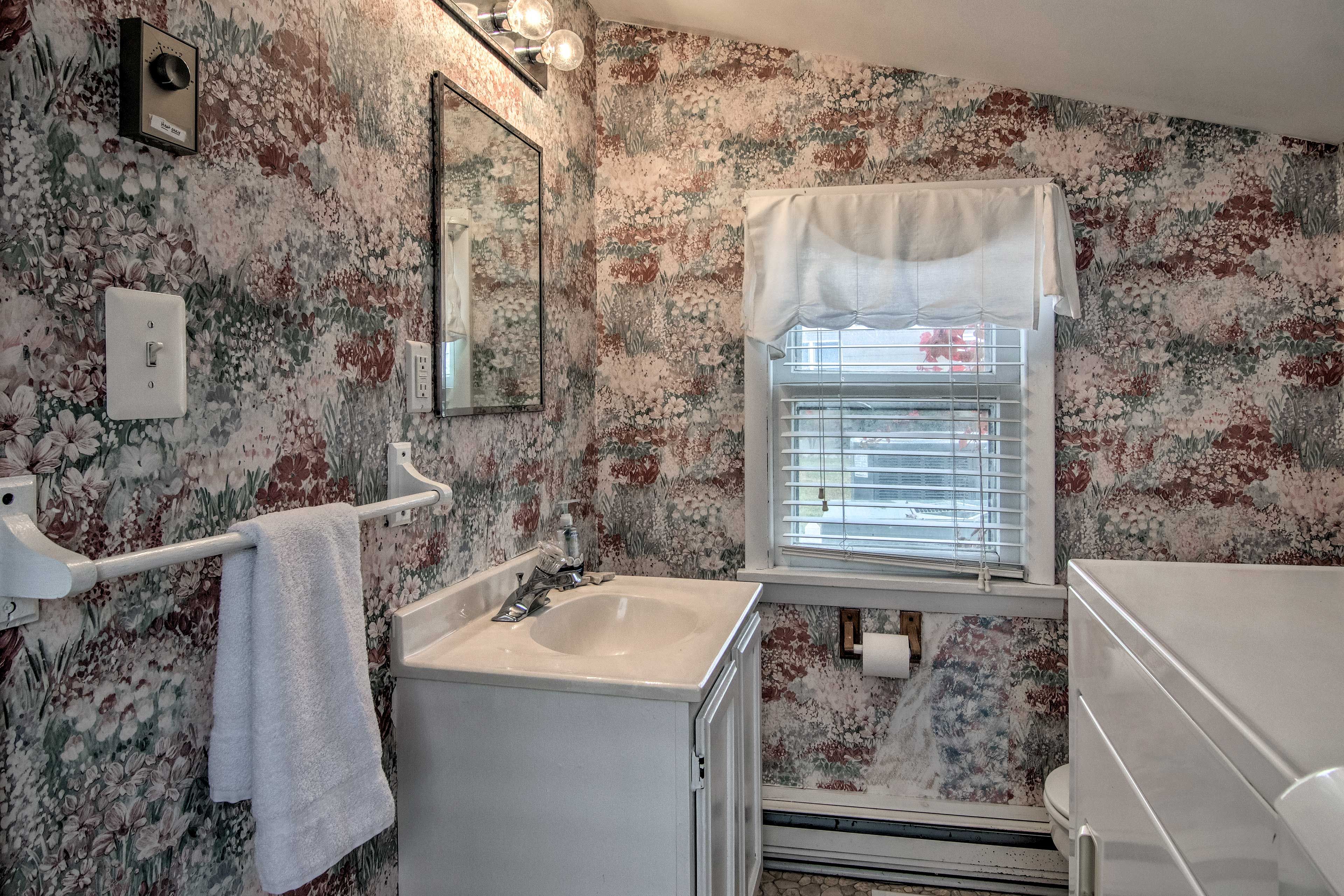 Bathroom 2 features floral wallpaper to match the Victorian vibe of this home.
