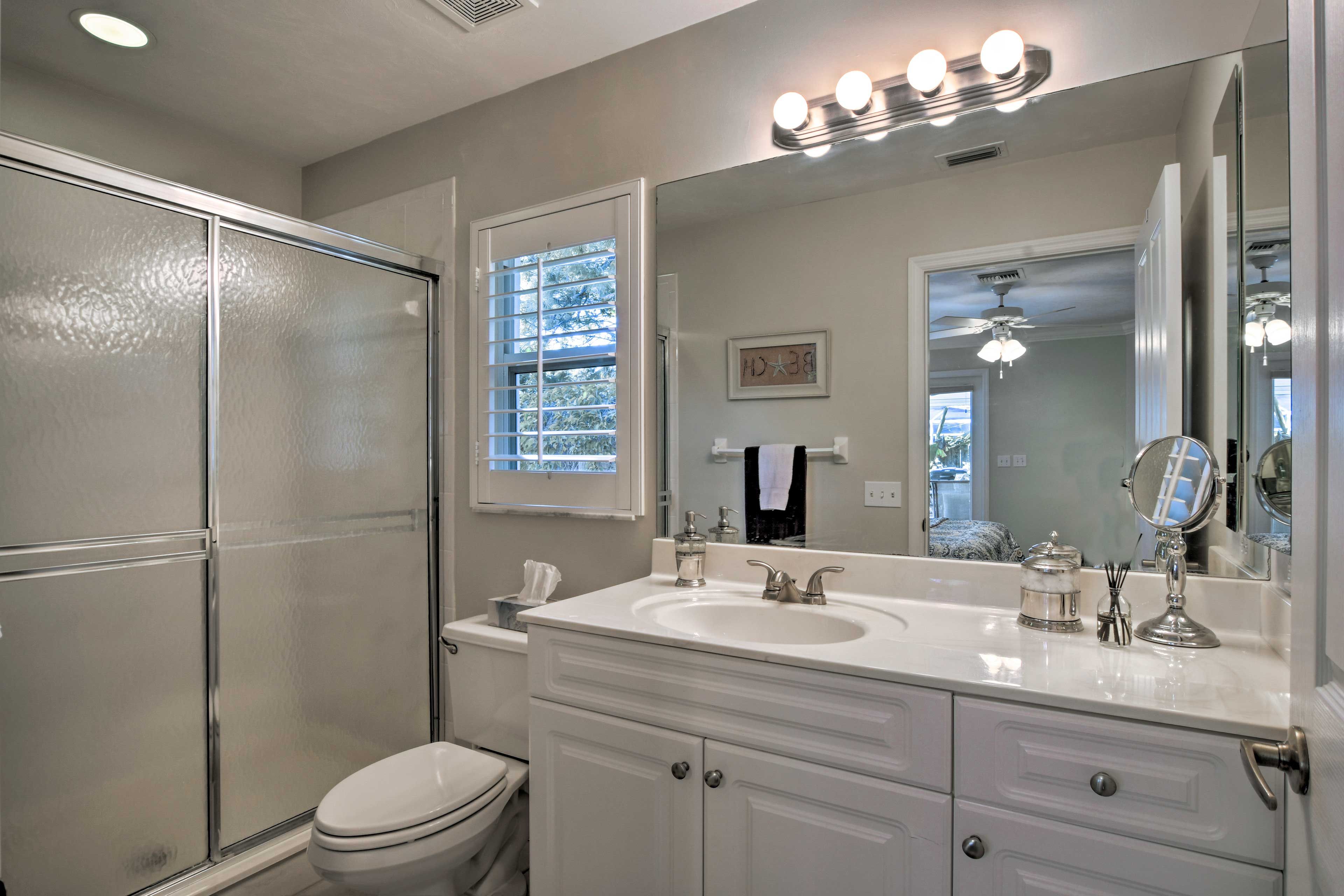 This full bath features a walk-in shower and mirrored vanity.
