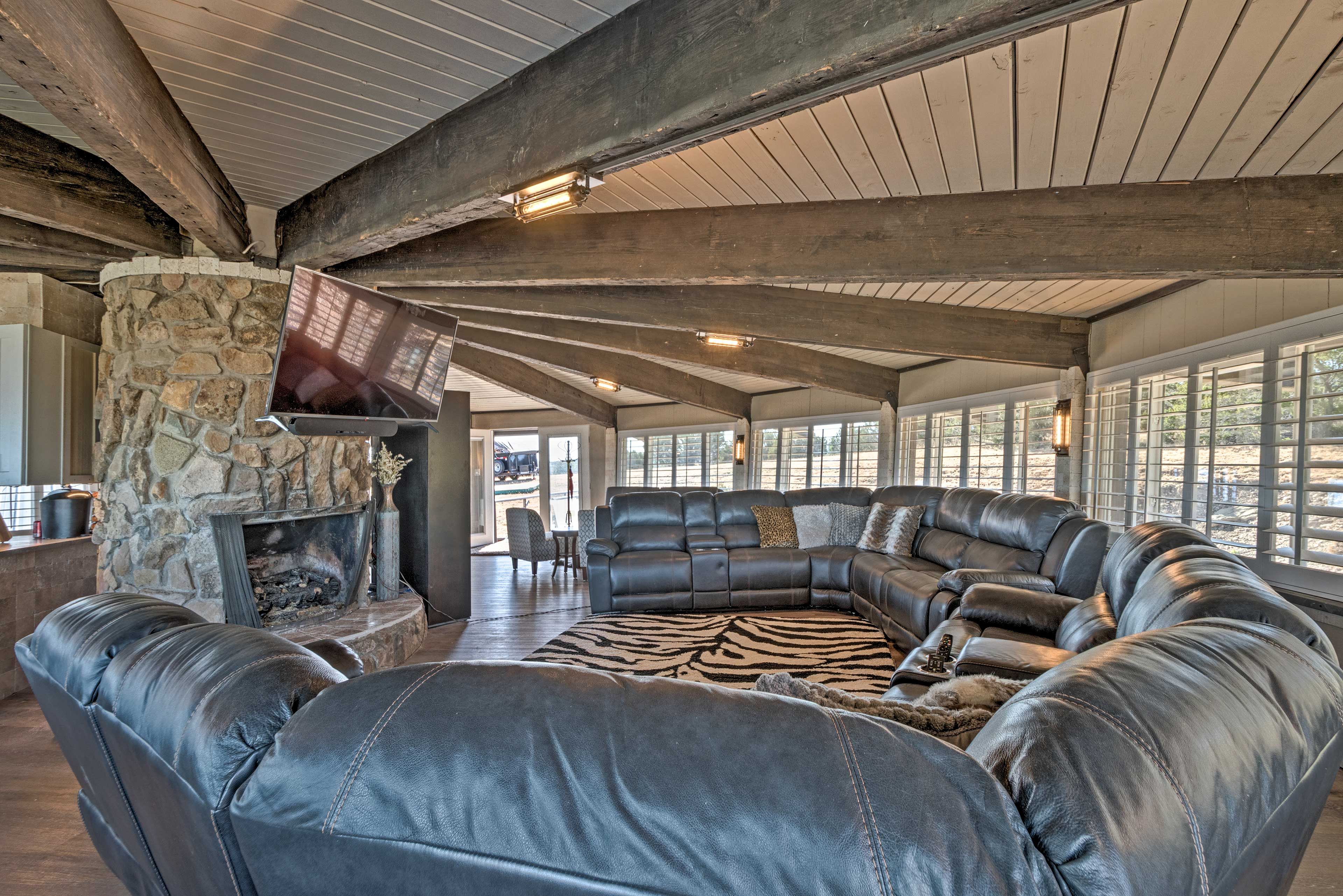 A stone-wall fireplace & flat-screen Smart TV center the room.