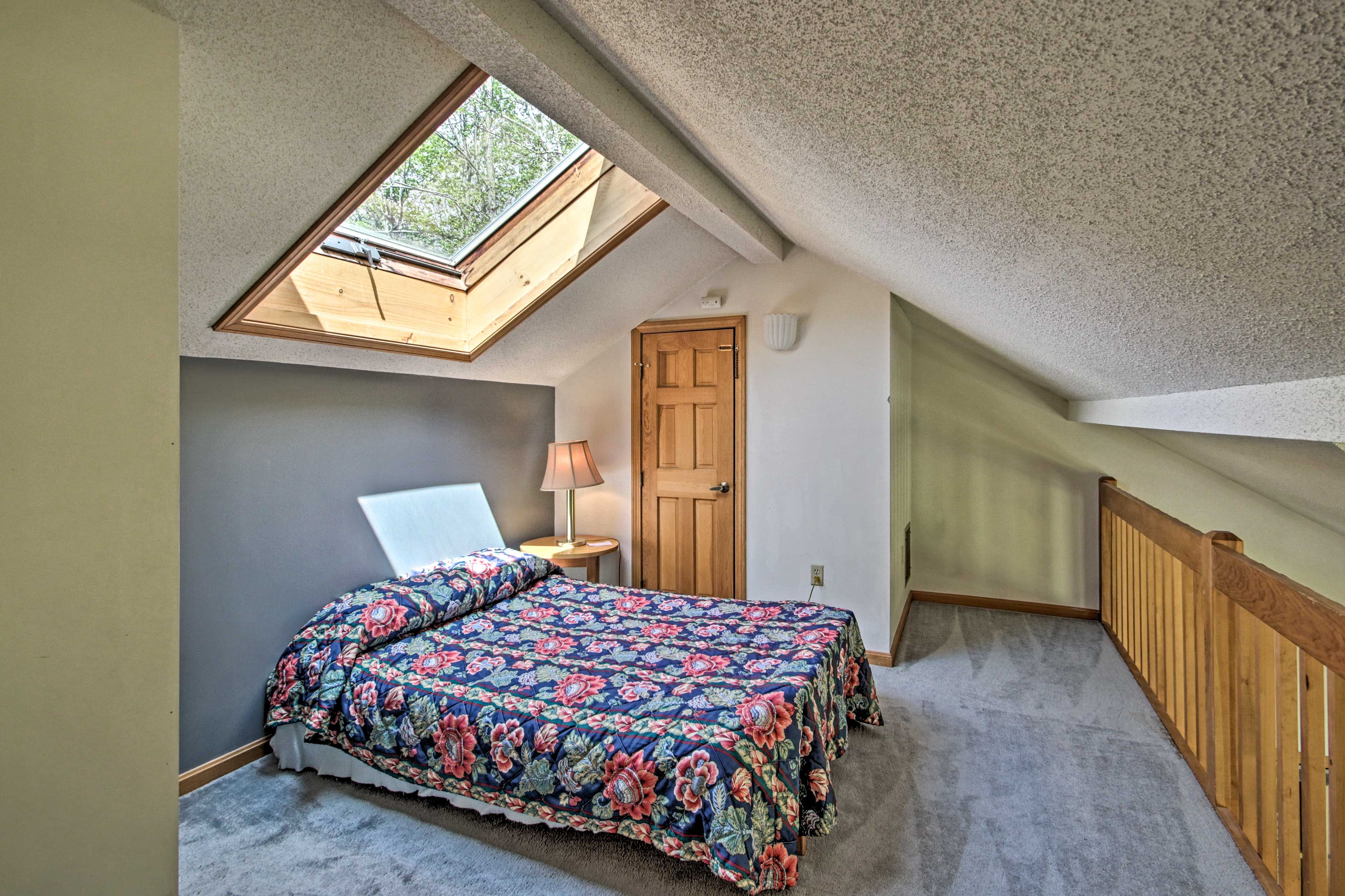 The loft area features a queen-sized bed and sunlight.