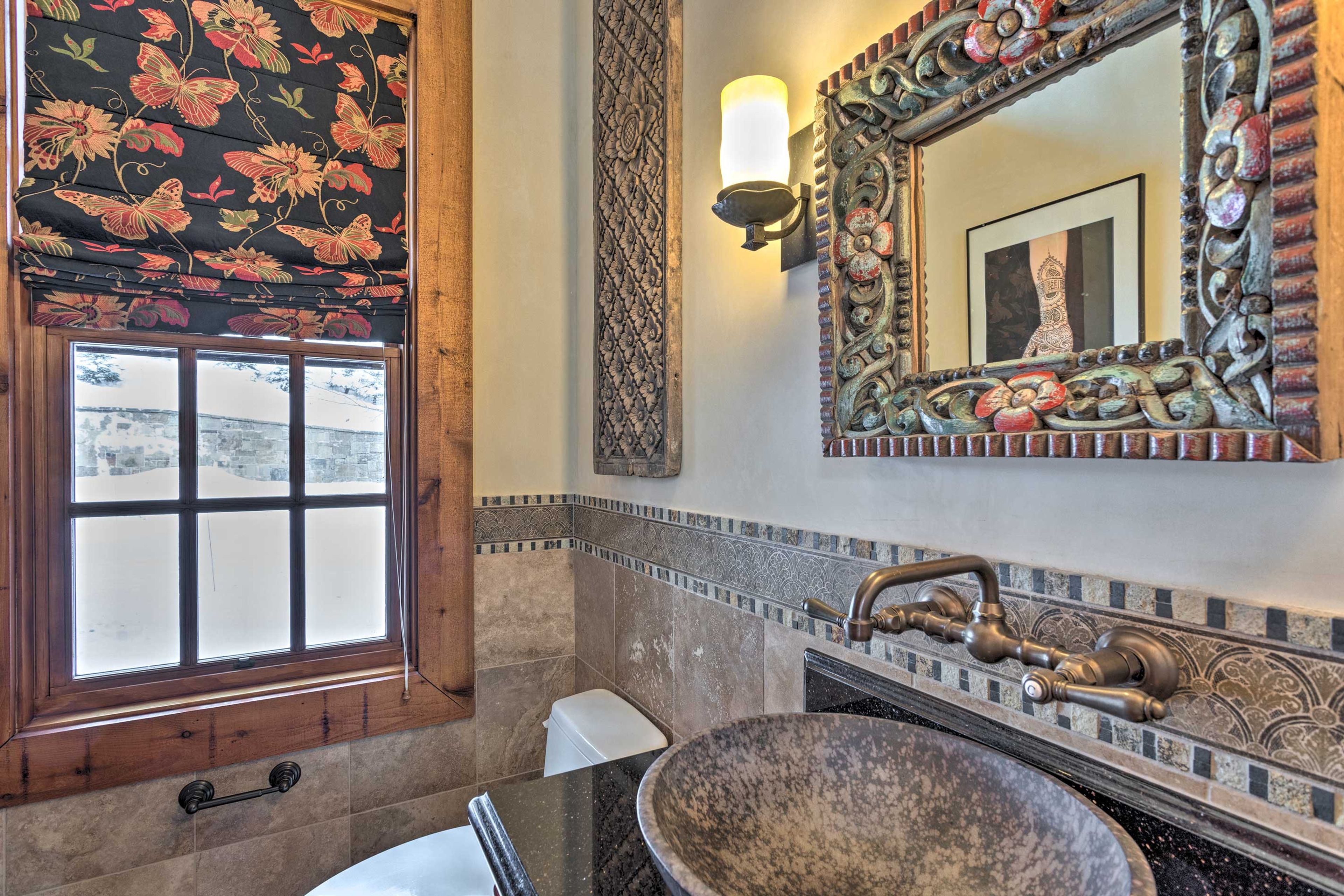 This bathroom features a vessel sink and granite vanity.