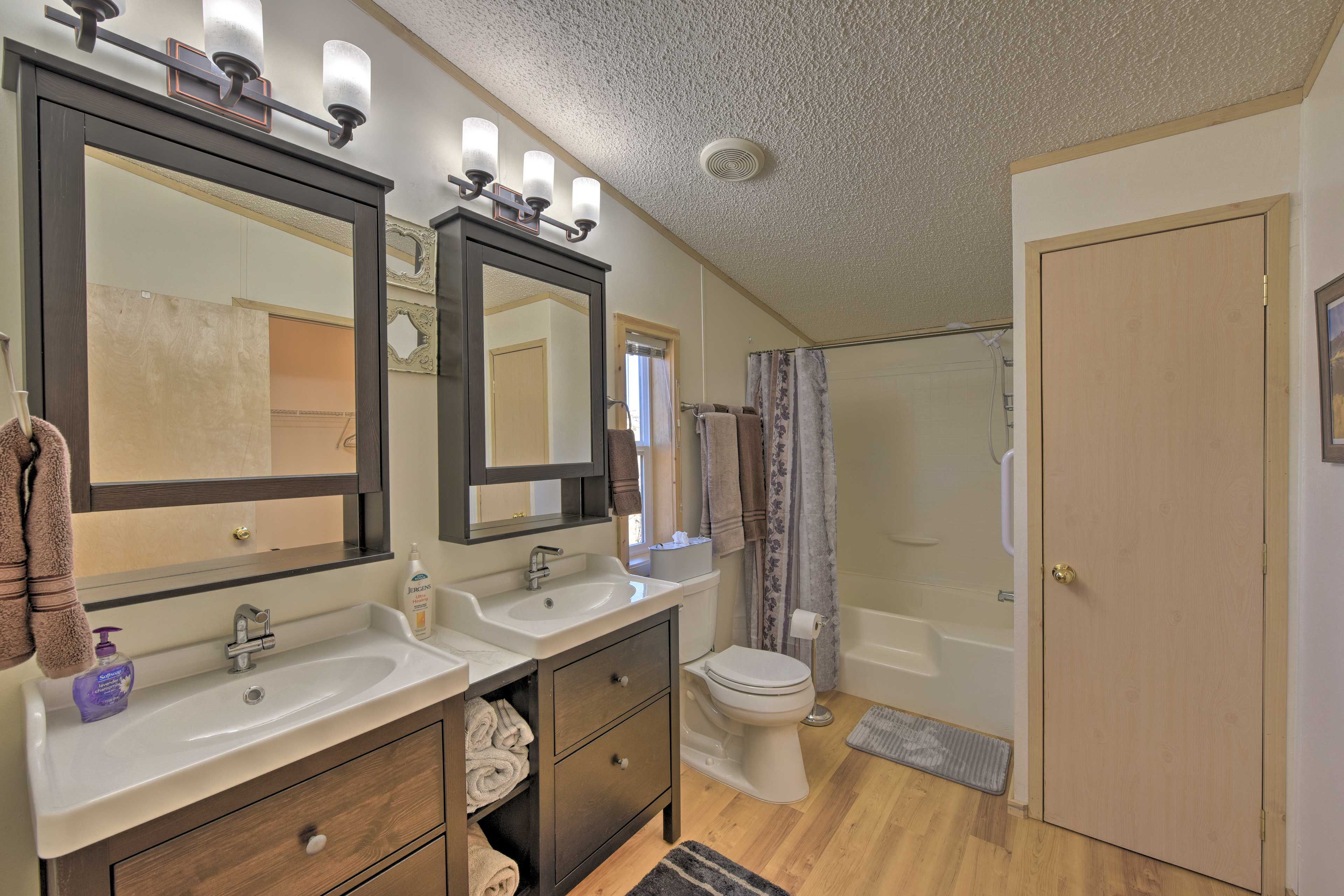 The en-suite bathroom offers a dual-sink vanity & shower/tub combo.