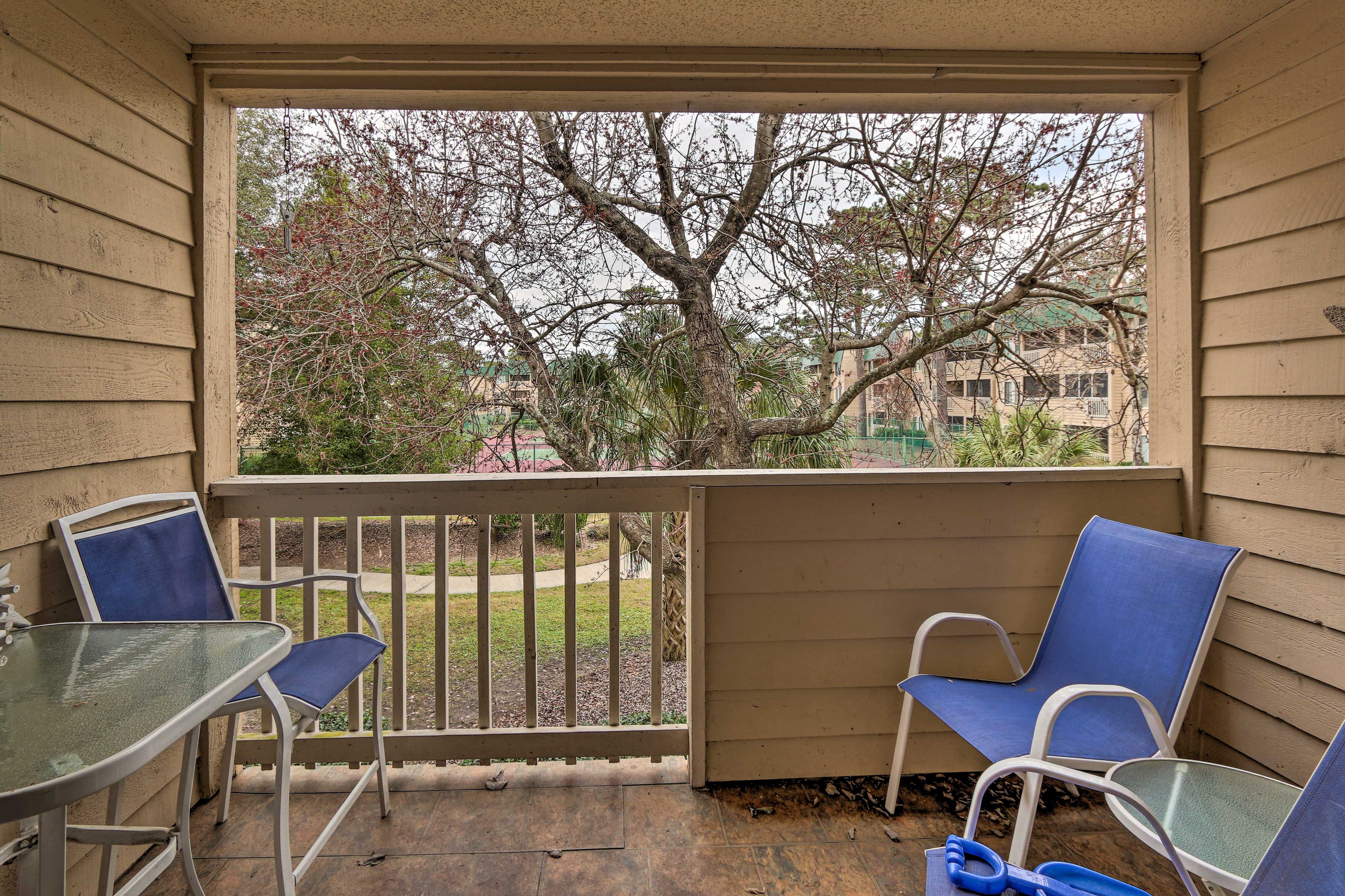 The covered balcony has lounge furniture and a dining table.