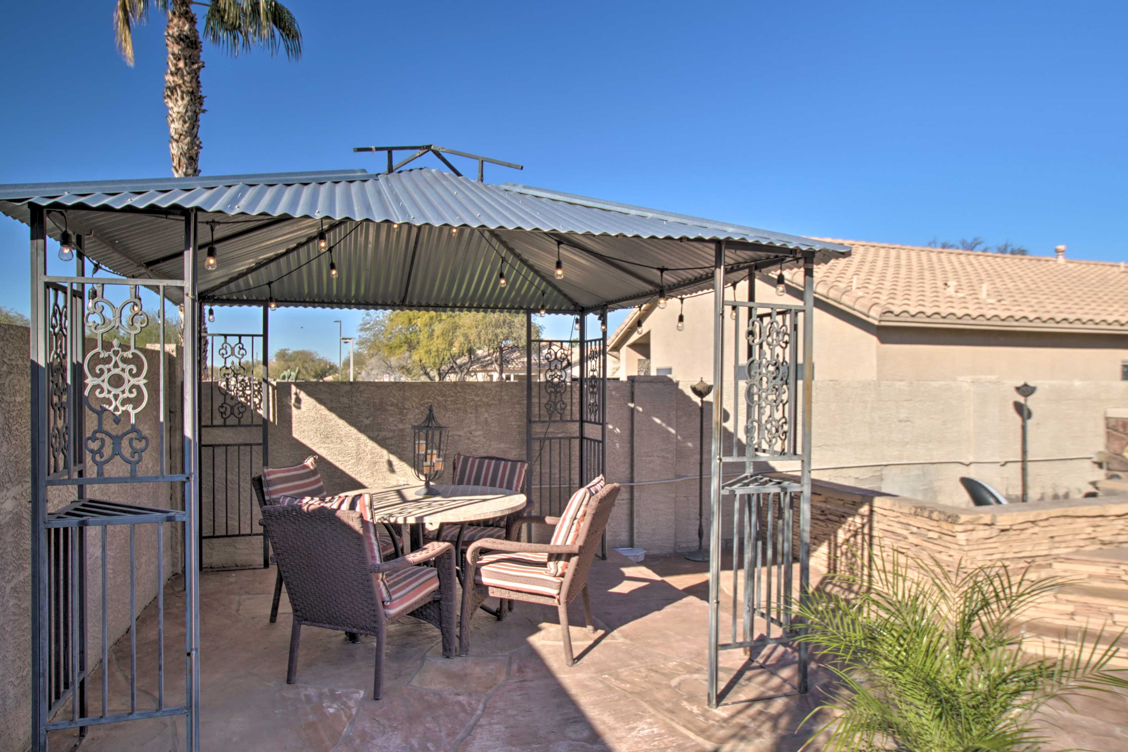 A gazebo is home to a second dining table and lighting for post-sunset fun.