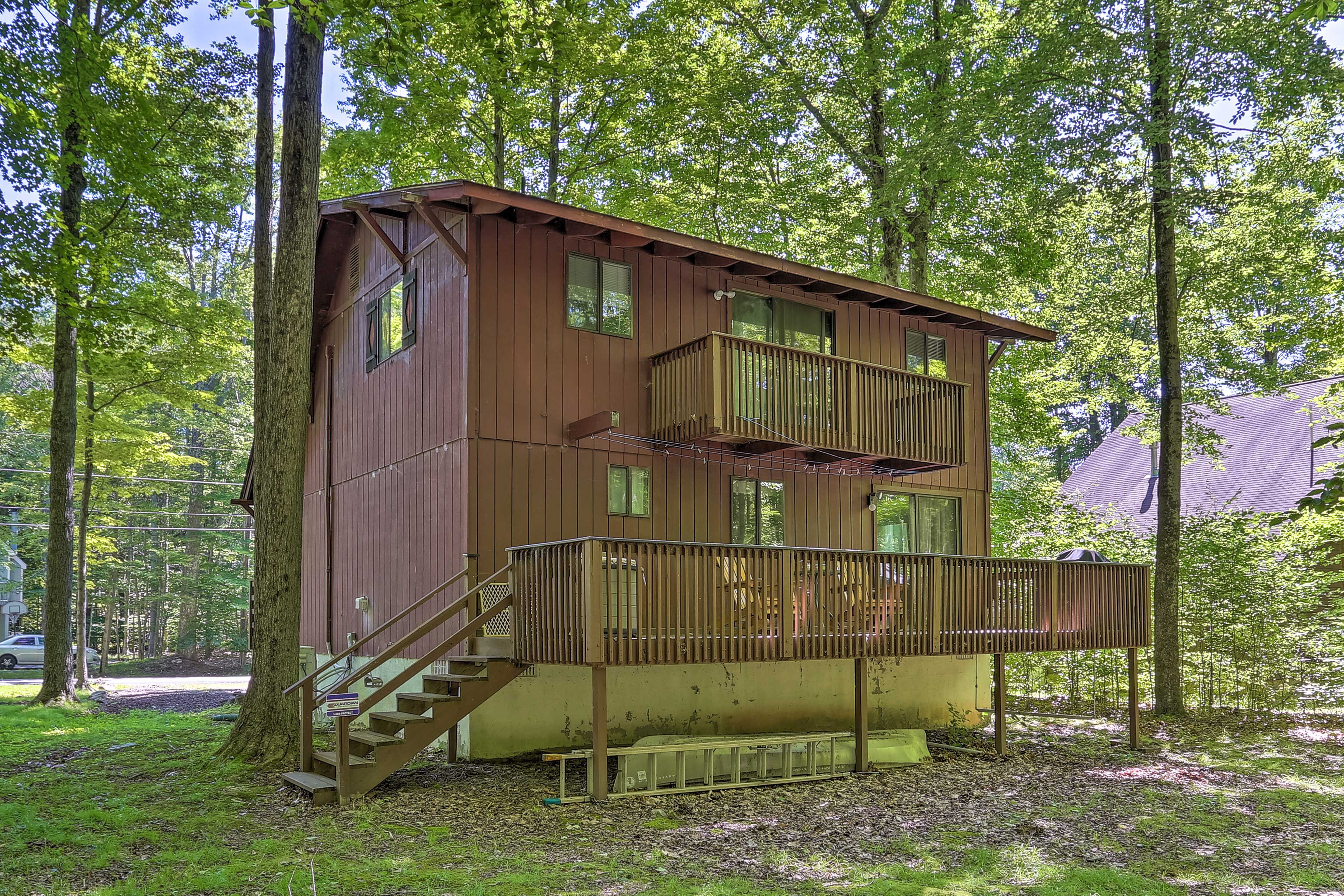 The second-story balcony has a beautiful view of the forest.