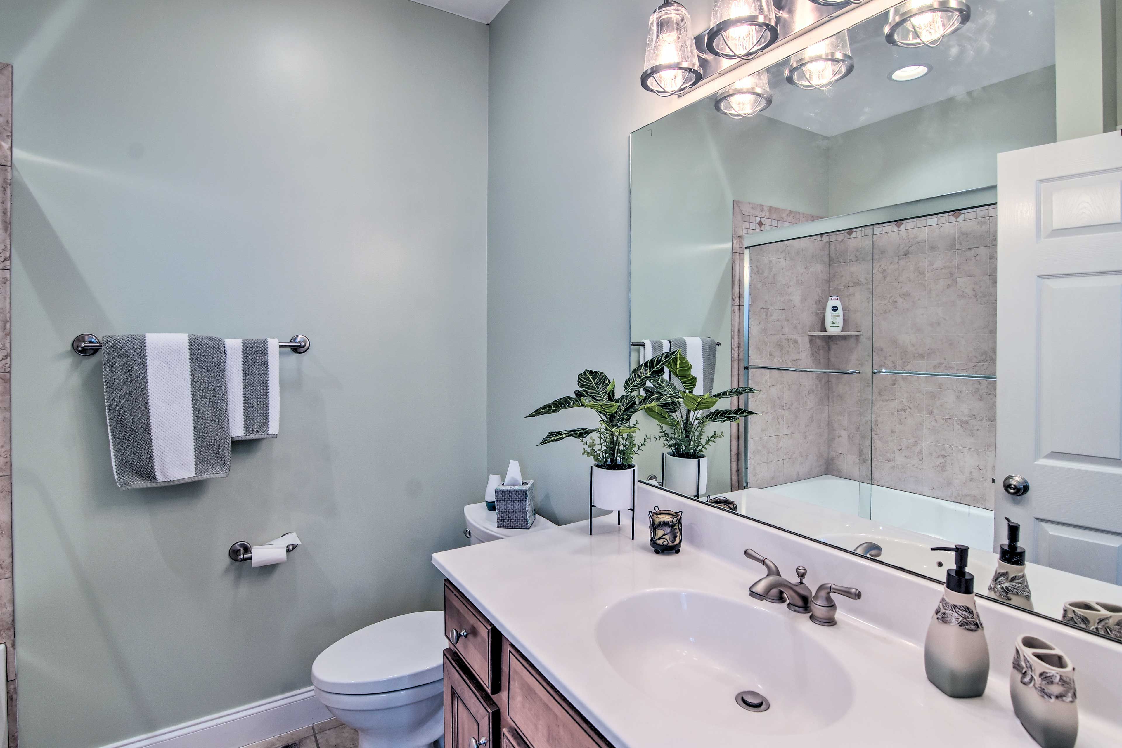 The en-suite bathroom has a shower/tub combo and modern decor.