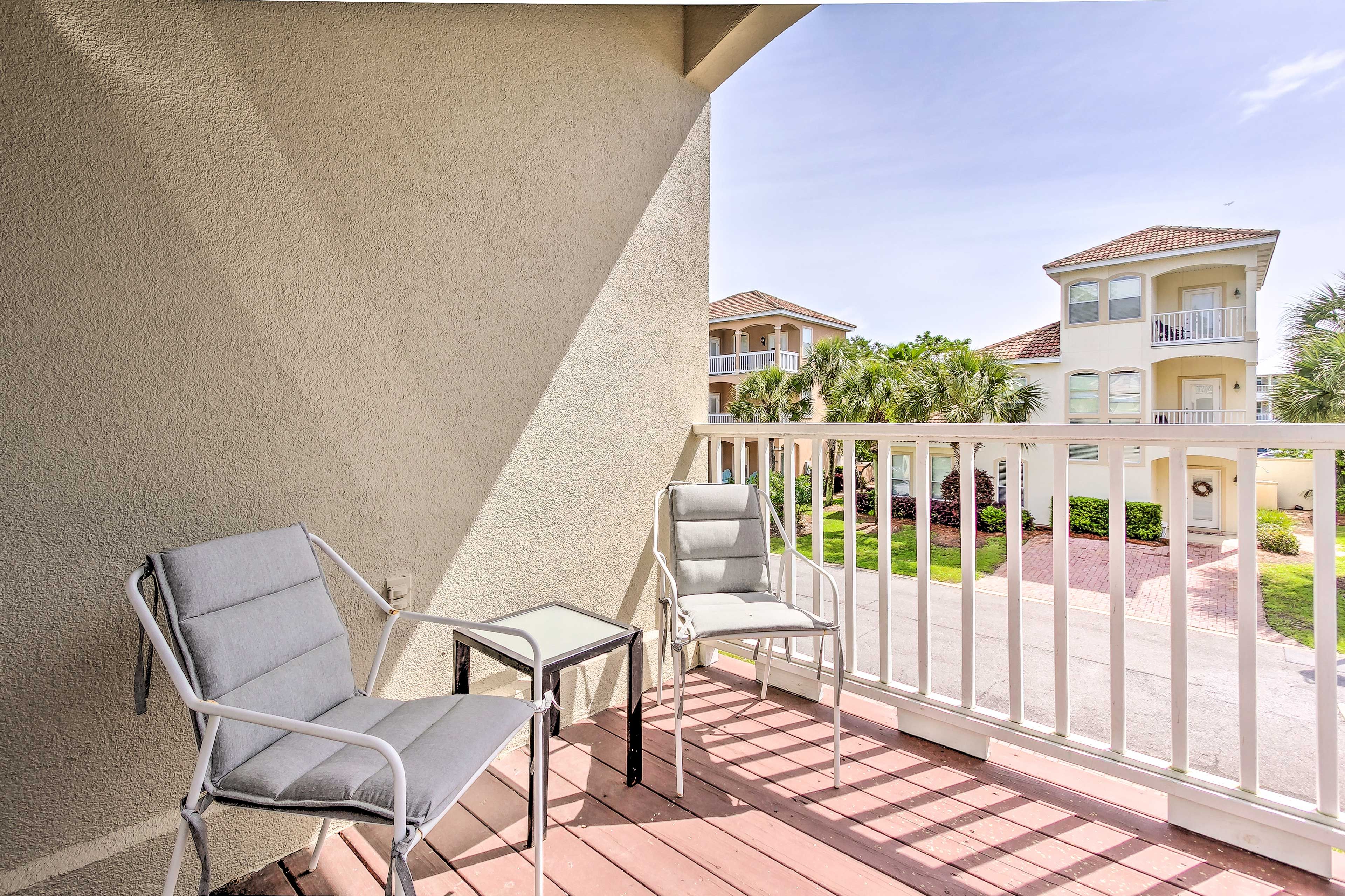 The bedroom also boasts a balcony with 2 chairs.
