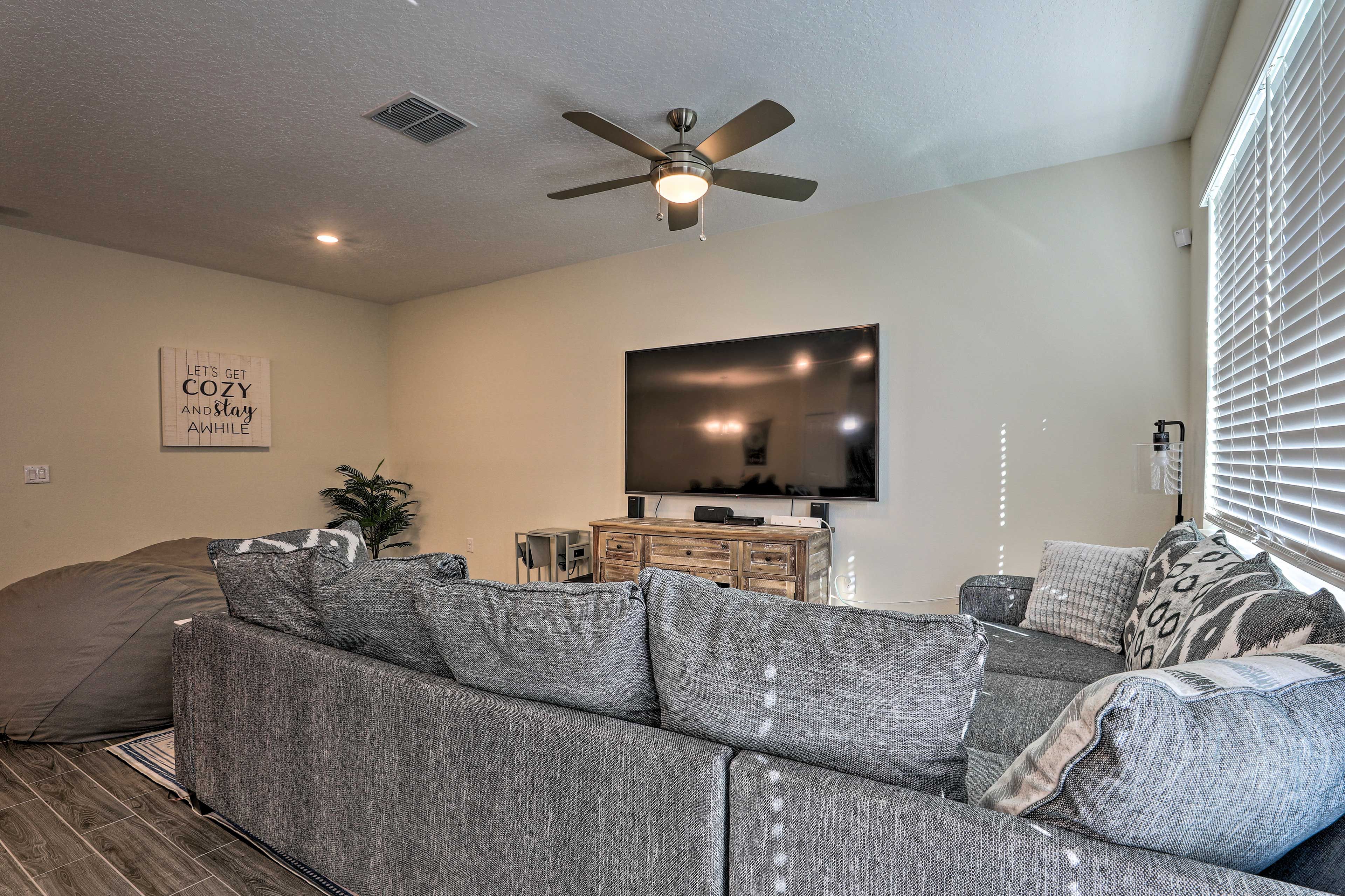 Enjoy a movie on the 82-inch home theater system with surround sound.