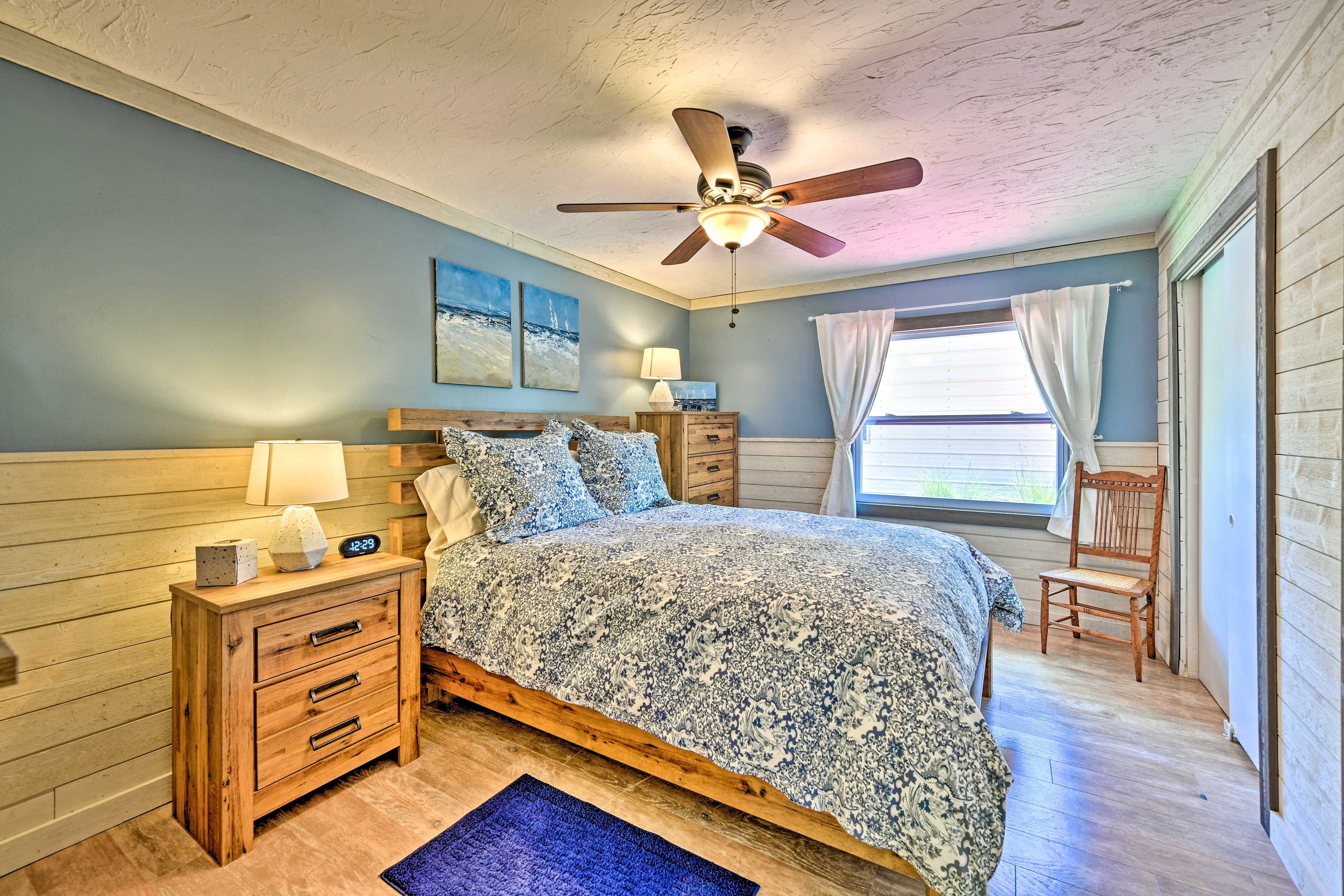 This serene sleeping space hosts a queen bed.