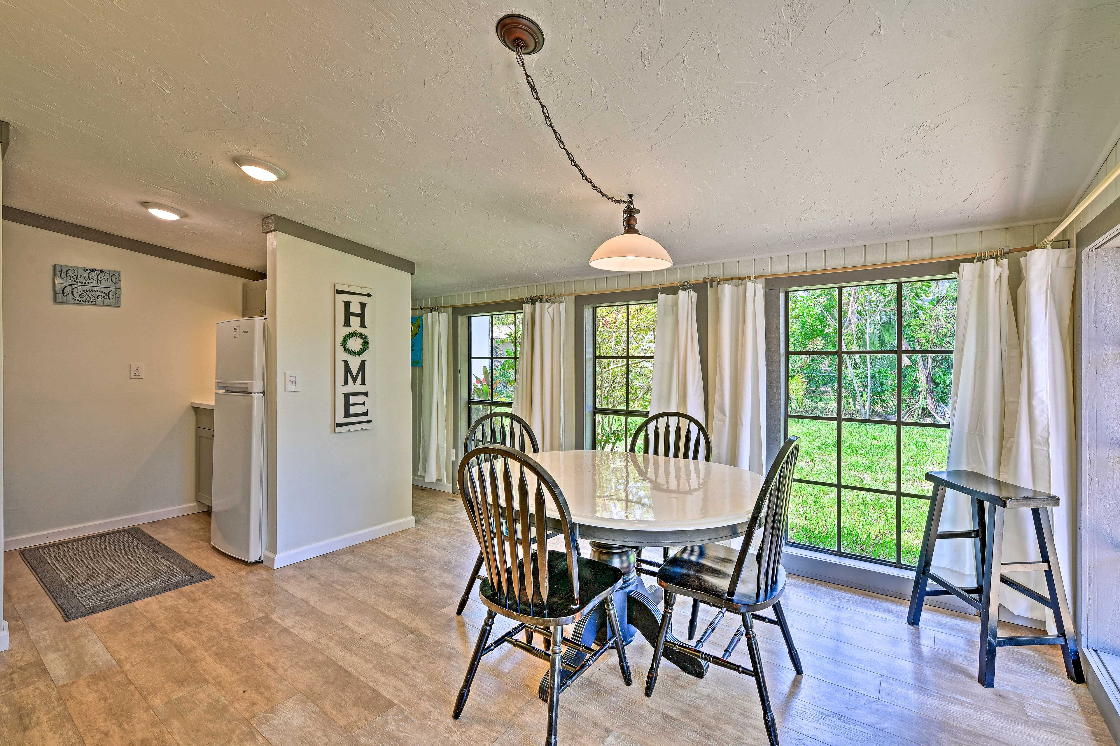 Floor-to-ceiling windows overlook the lush yard.
