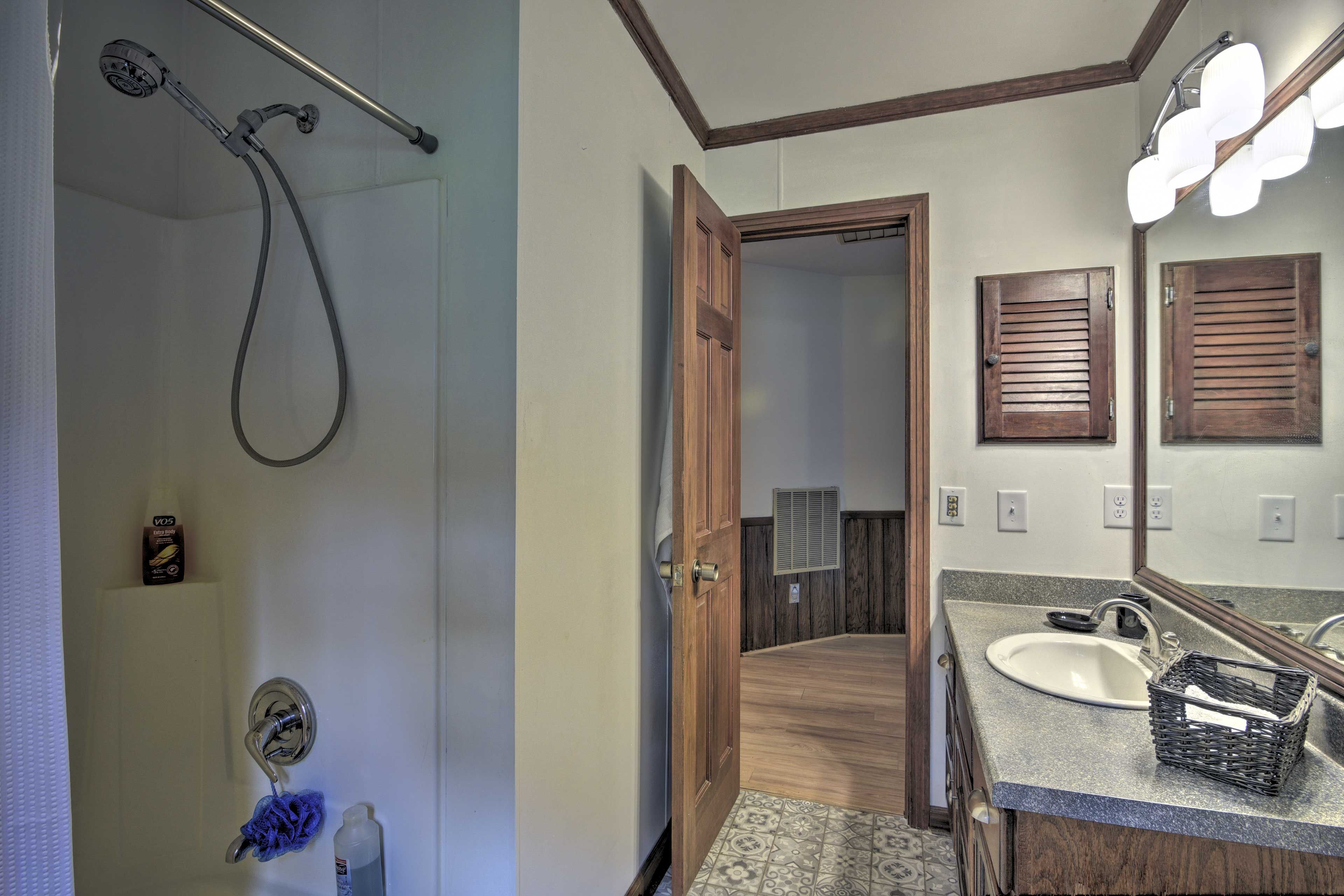 This full bathroom hosts a shower/tub combo.