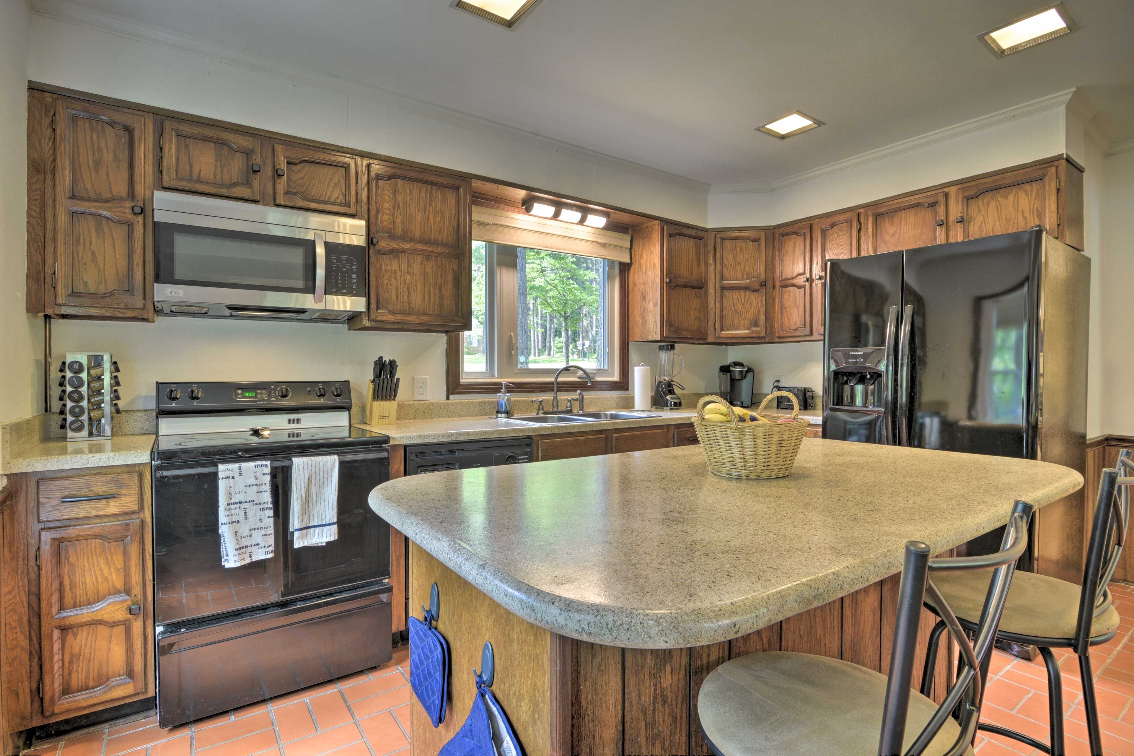 The kitchen is fully equipped, featuring an island with seating for 2.