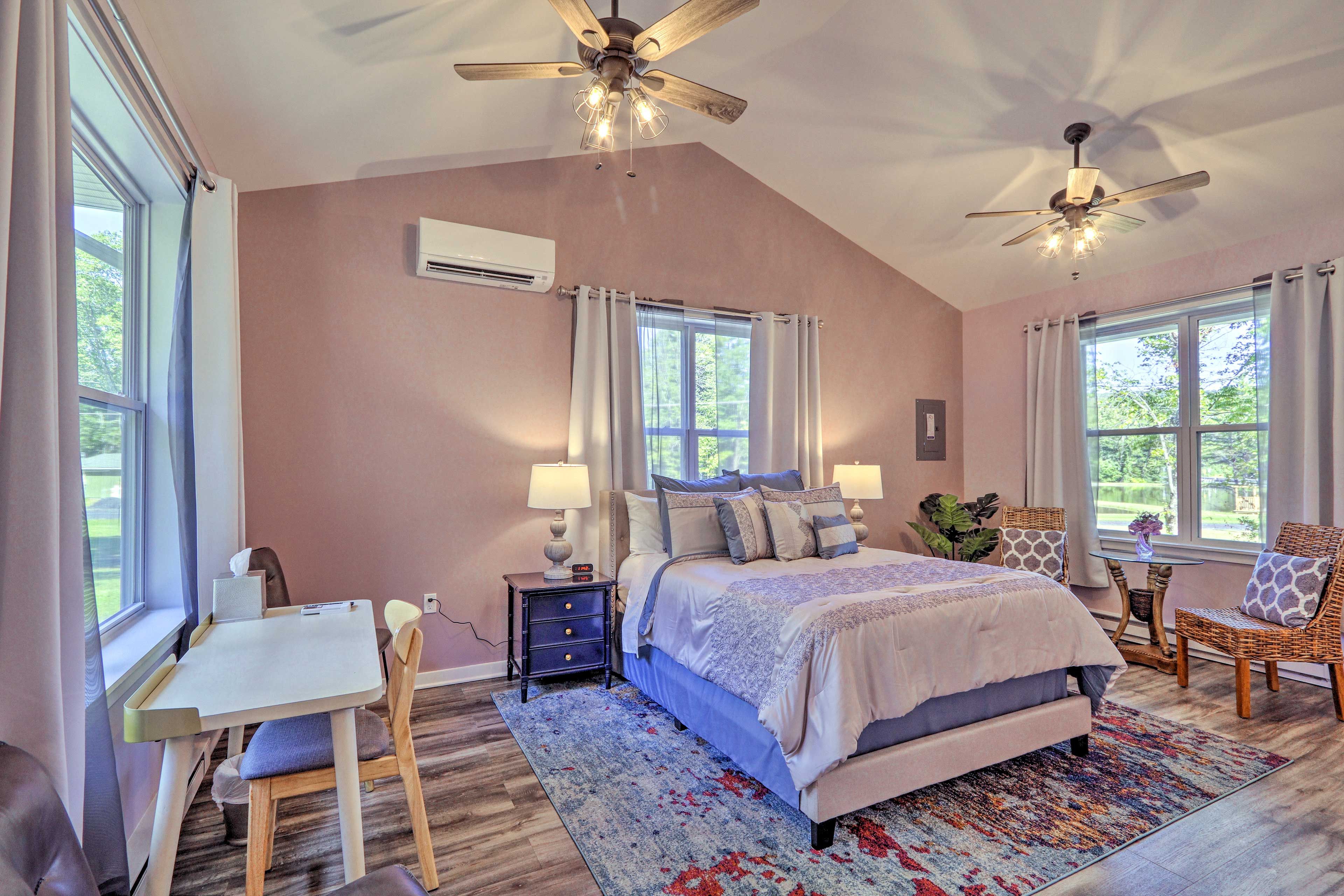 The bedroom boasts a queen bed, desk space, and nice sitting area.