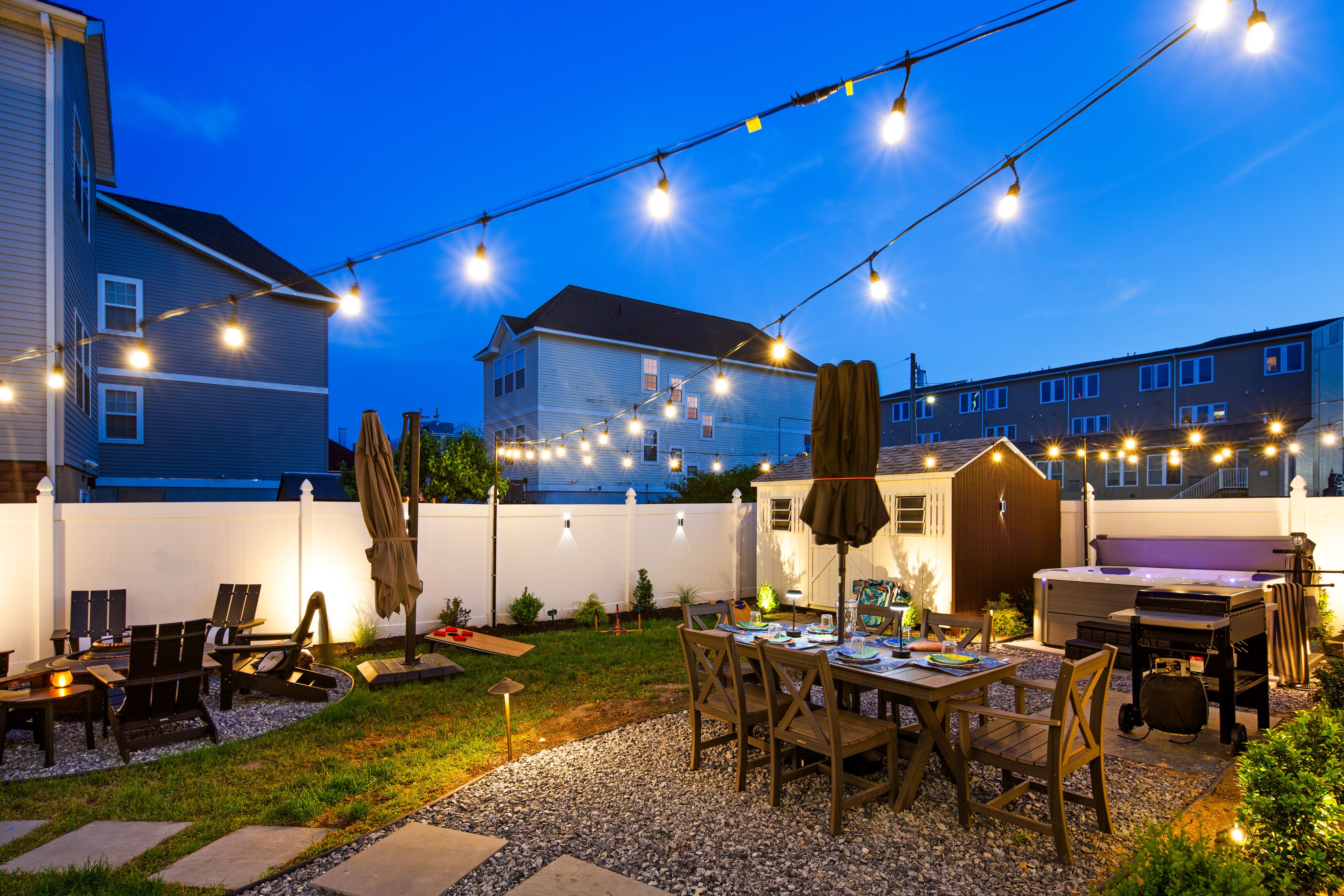 Private backyard oasis, beautifully illuminated by overhead string lights