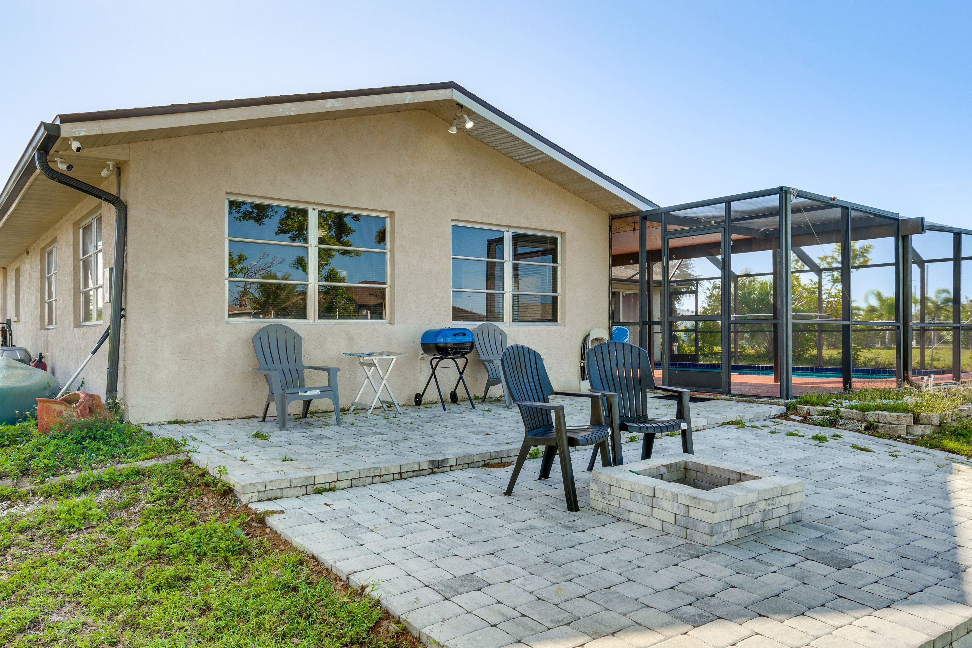 Property Exterior | Screened-In Lanai w/ Pool | Patio w/ Grills & Fire Pit