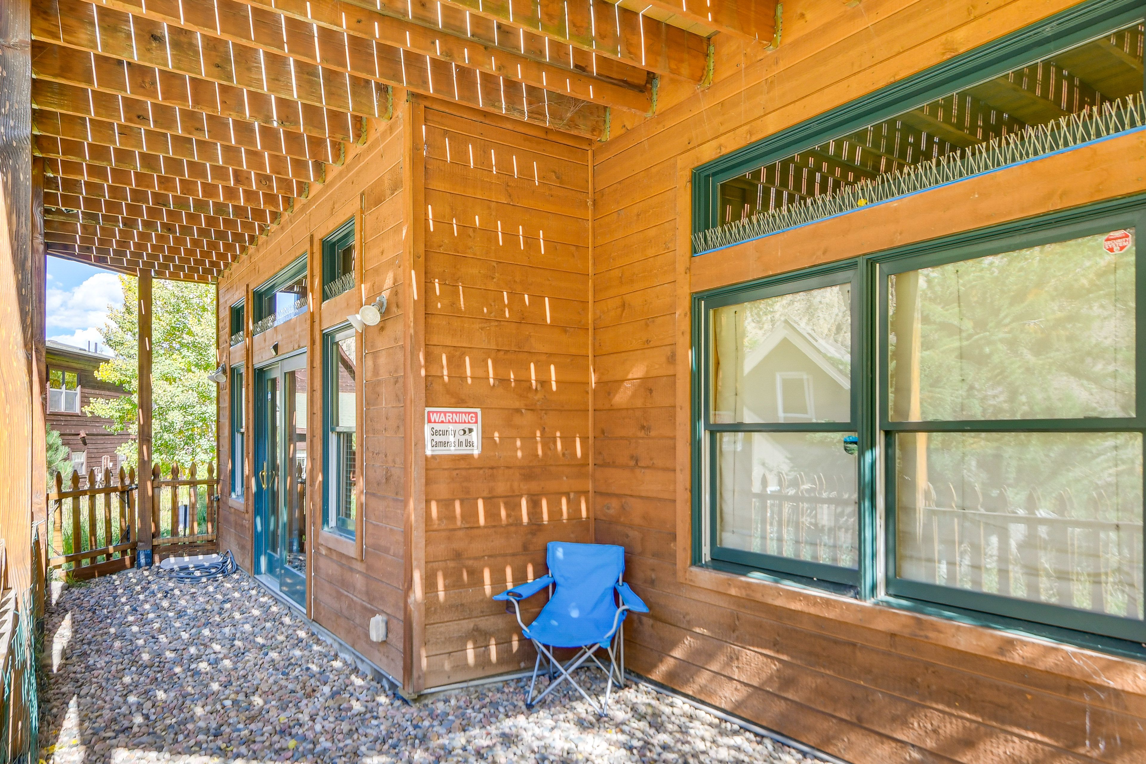 Cabin Exterior | Covered Gravel Patio w/ Seating