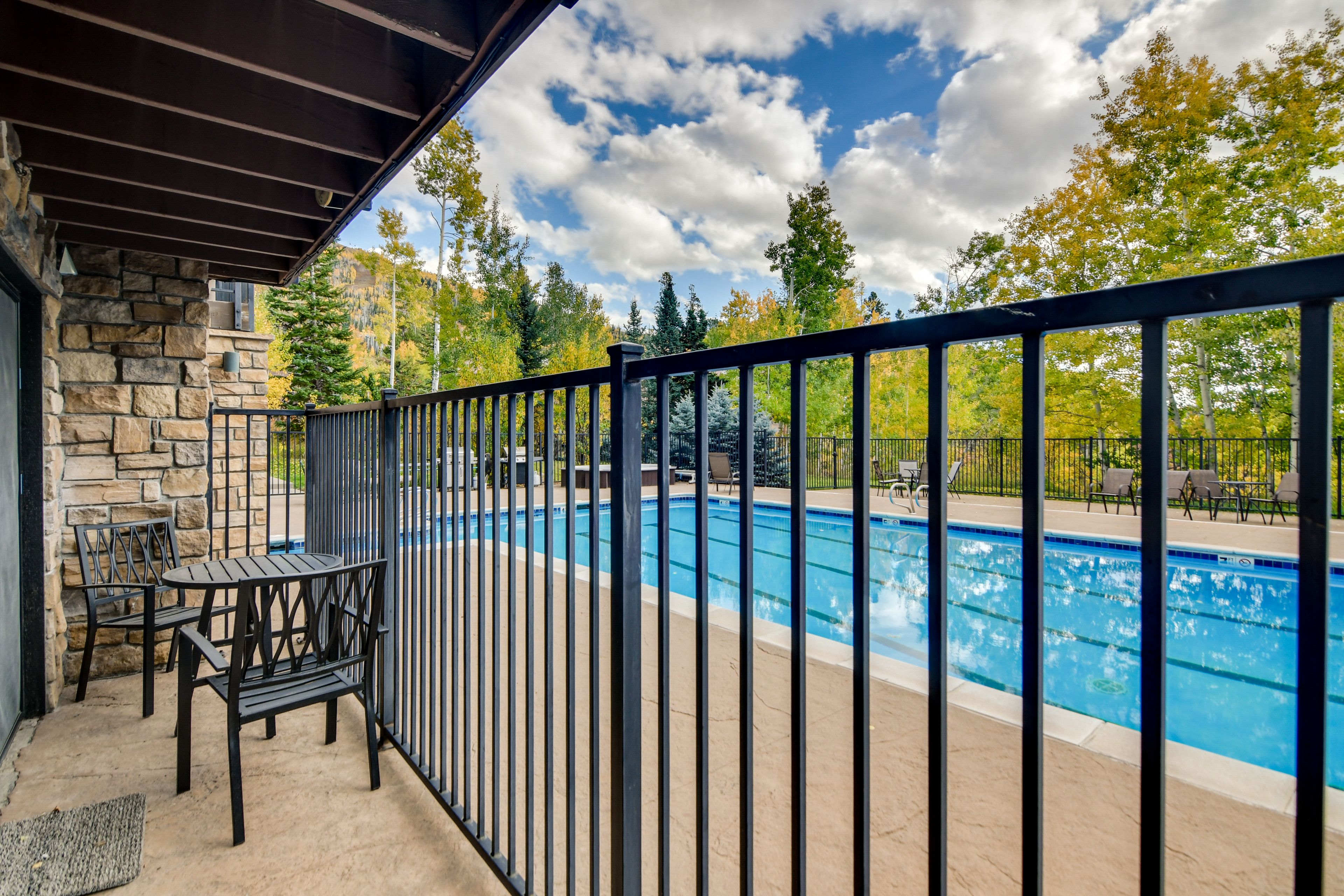 Condo Exterior | Covered Patio w/ Dining Area & Pool View