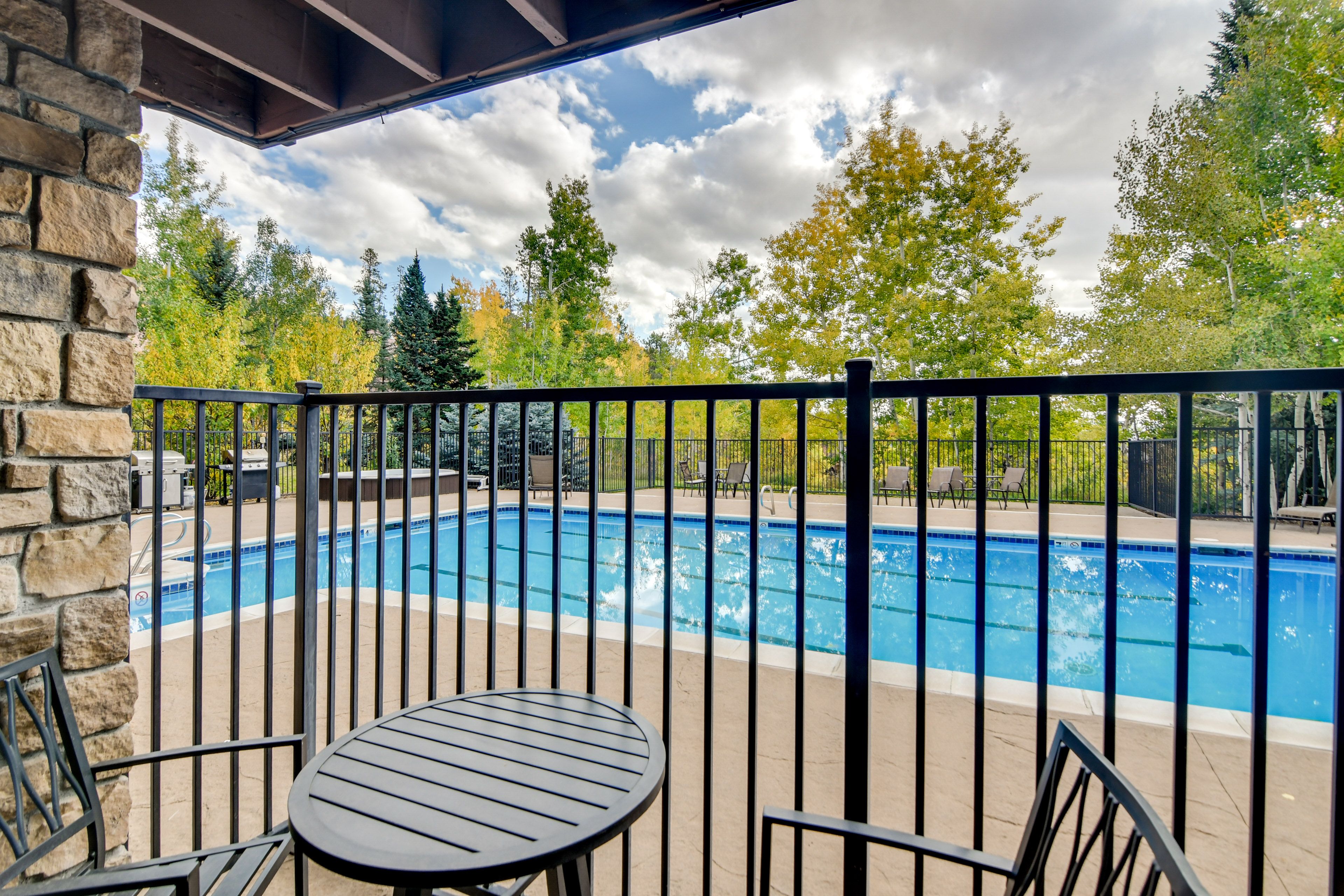 Condo Exterior | Covered Patio w/ Dining Area & Pool View
